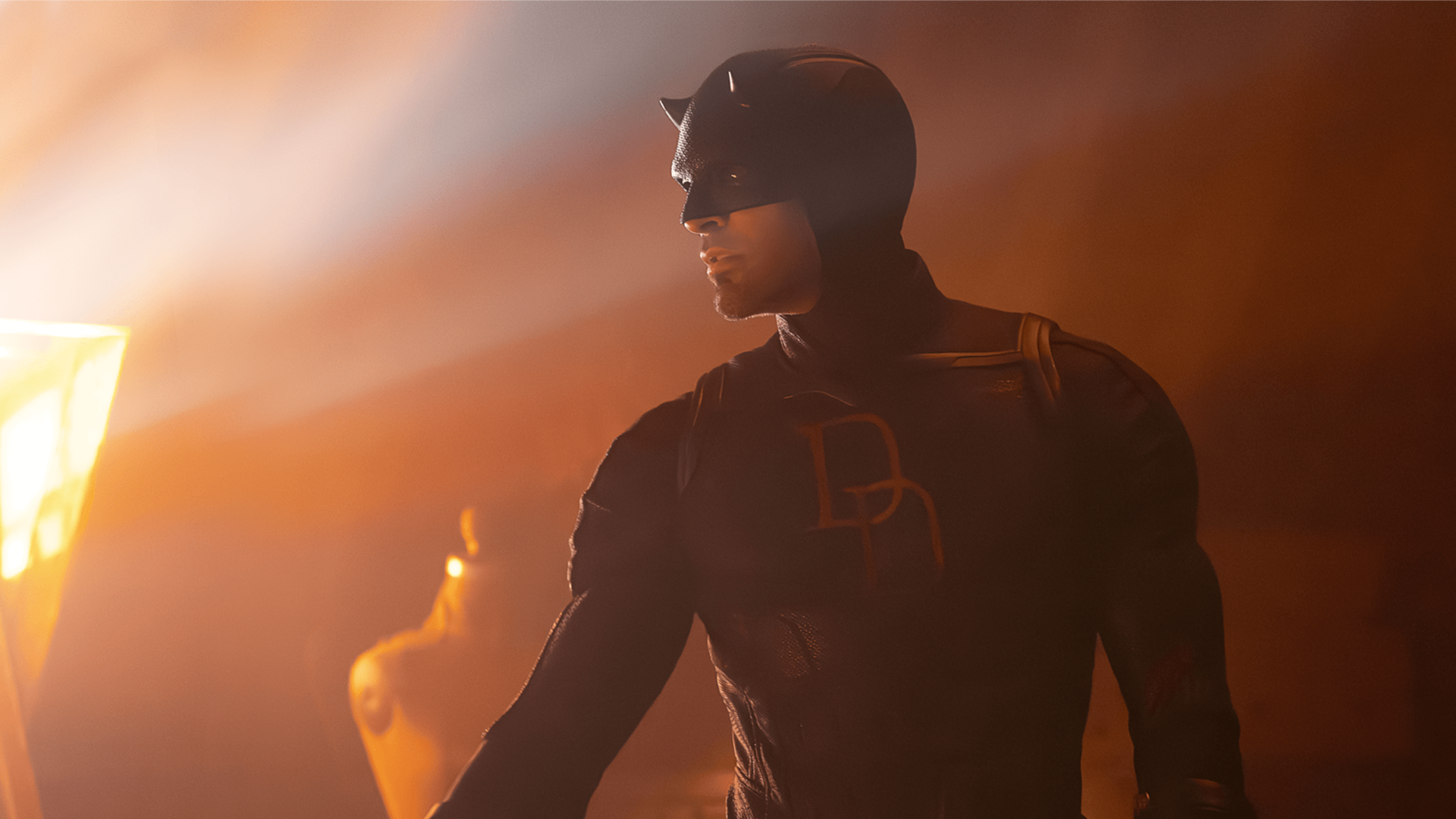 Close-up shot of Daredevil illuminated by flames in a burning building.