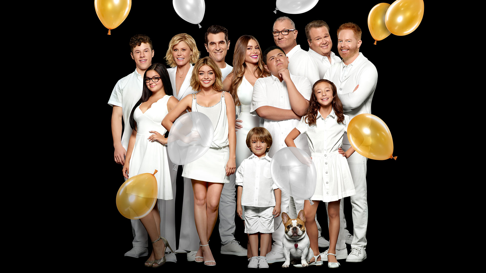 Key art for Modern Family featuring the extended family gathered together in white outfits with gold and silver balloons surrounding them.
