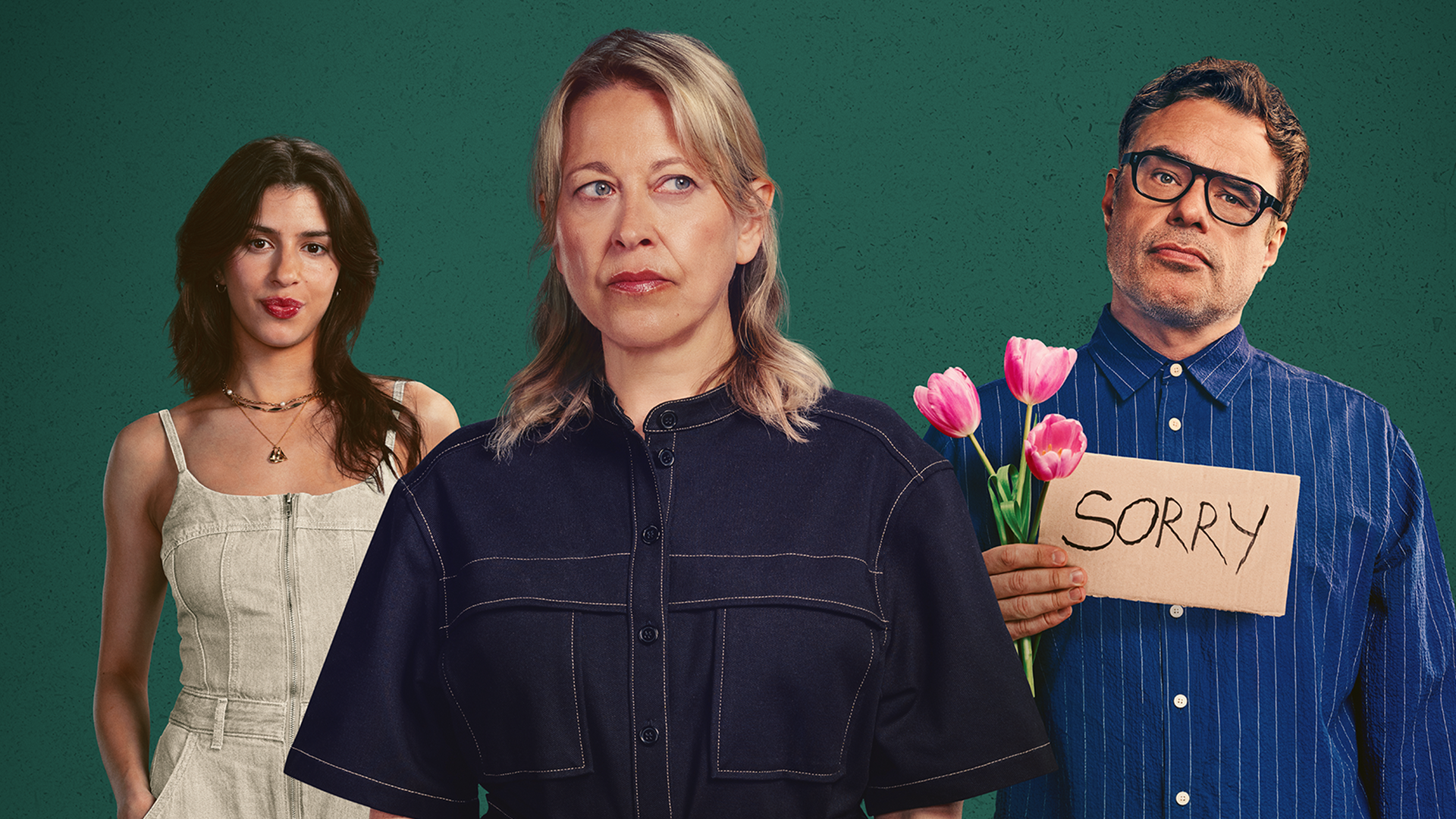 An official promotional image for the comedy-drama series Alice and Steve, featuring Nicola Walker as a sceptical Alice in a black utility-style shirt standing front and centre. Behind her on the left is Yali Topol Margalith as Izzy in a white denim jumpsuit, while on the right, Jemaine Clement as Steve holds a bouquet of pink tulips and a cardboard "SORRY" sign against a dark green textured background.