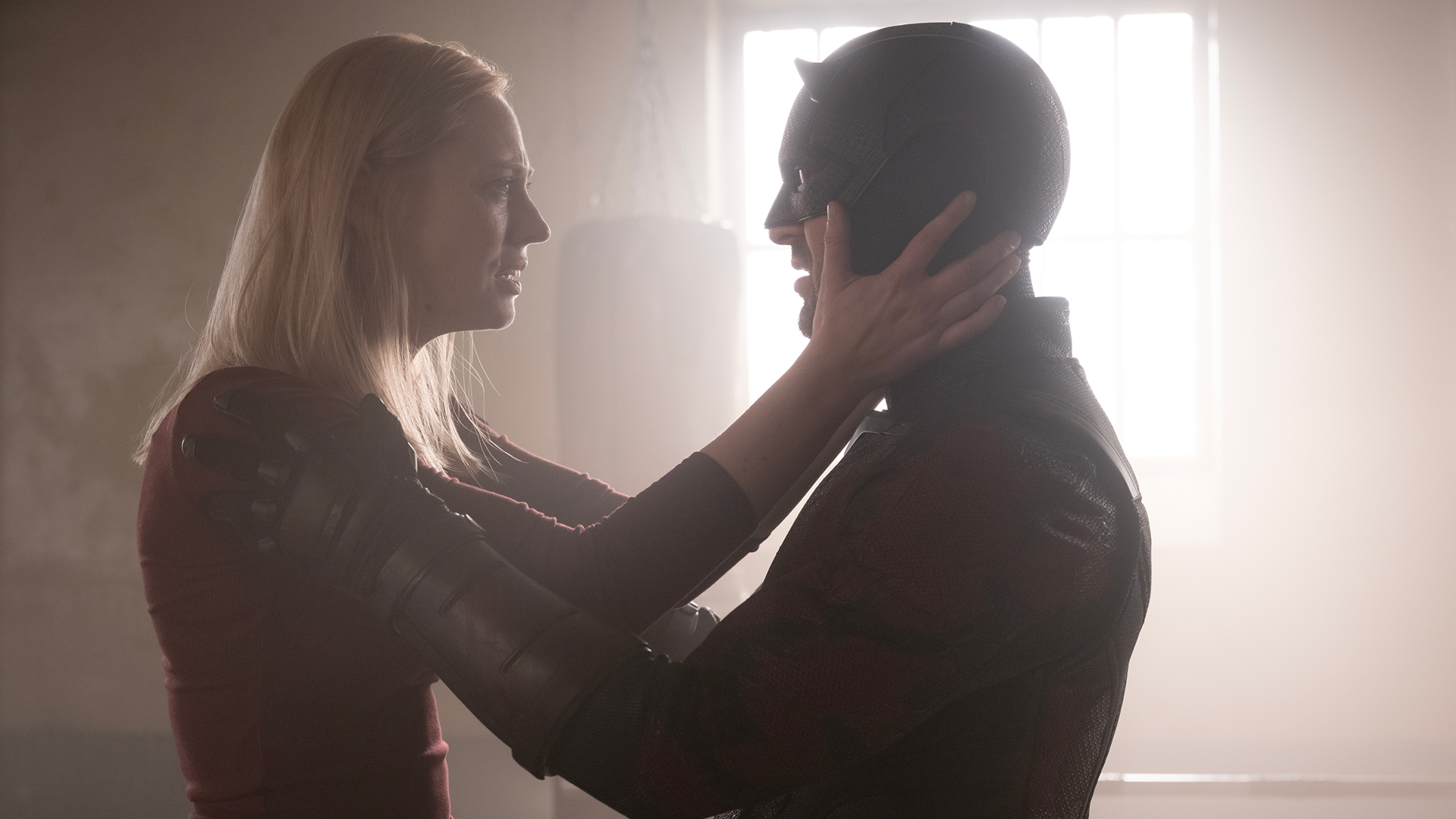Karen Page (Deborah Ann-Woll) and Daredevil a.k.a Matt Murdock (Charlie Cox) embrace each other.
