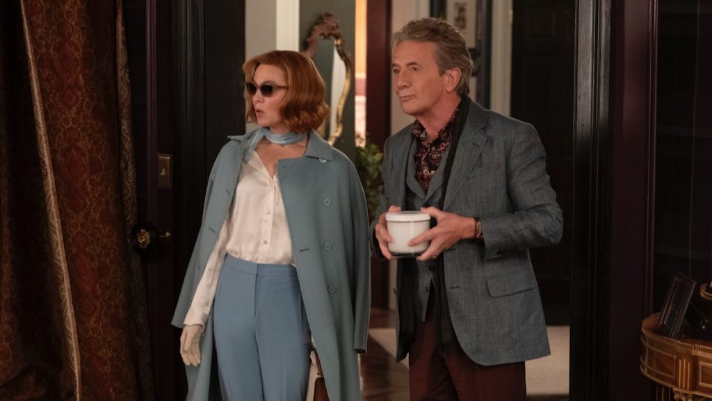 Renée Zellweger, wearing a light blue coat and sunglasses, stands beside Martin Short.