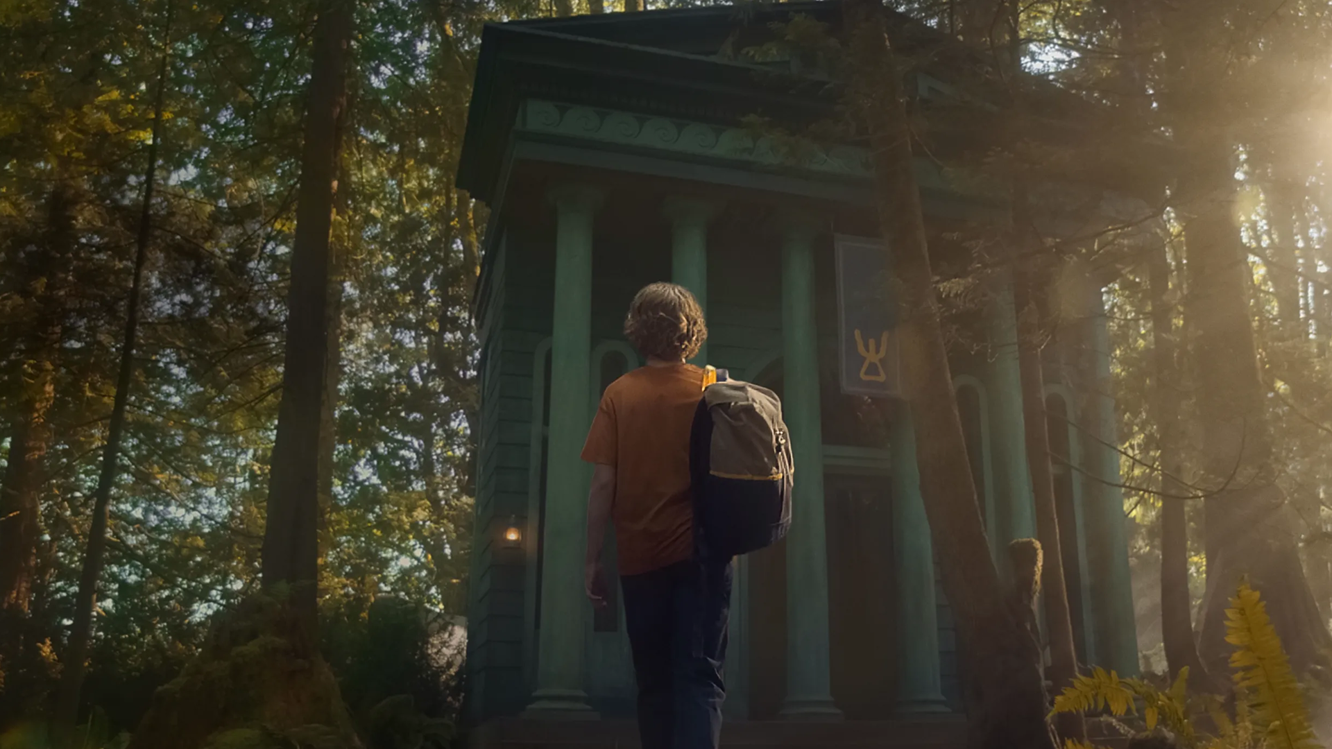 パーシー・ジャクソン（ウォーカー・スコベル）が森の中の大きな建造物に近づいている。