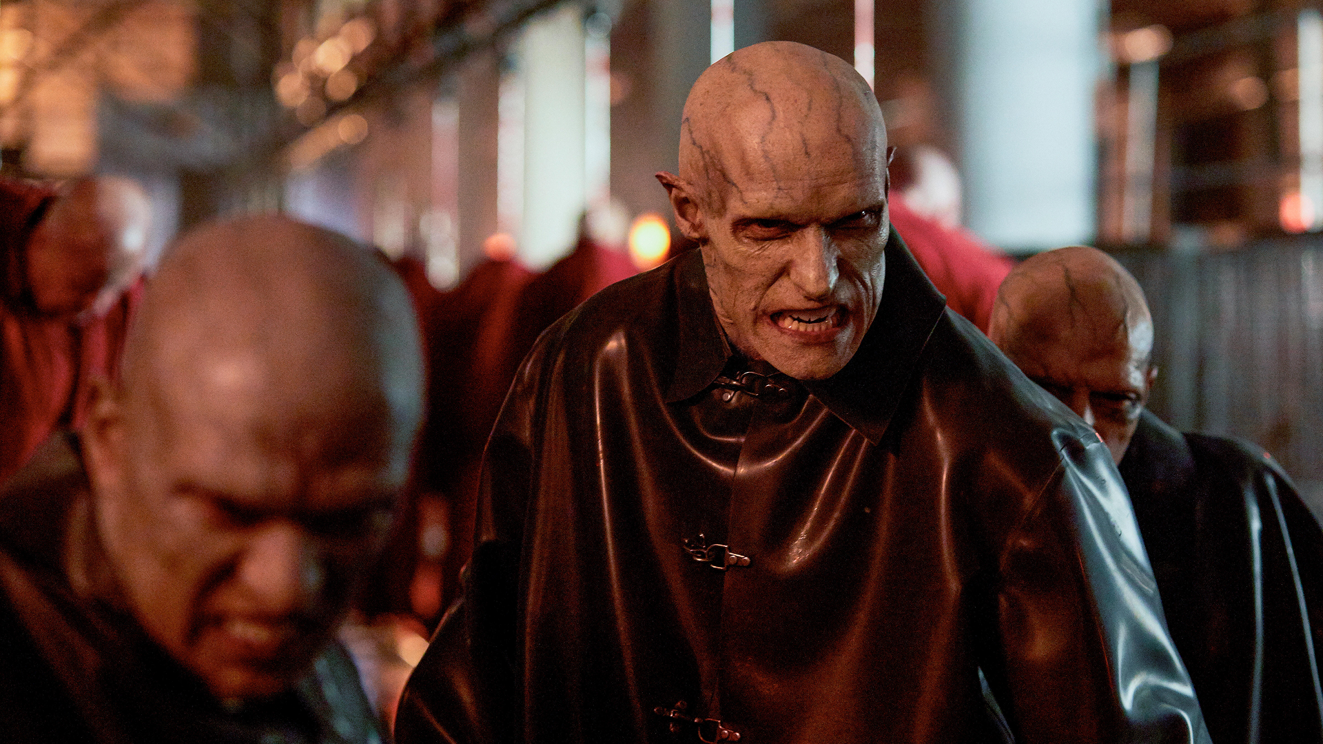 Three scary looking, bald men with visible blue veins on their heads and faces