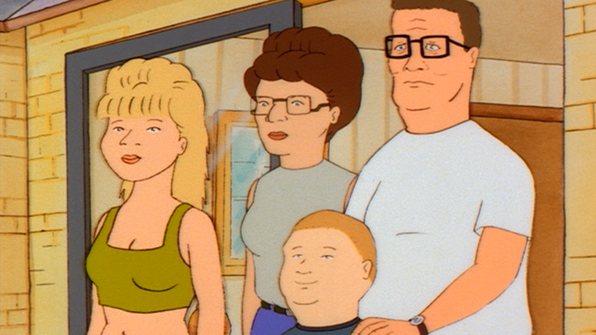 Luanne (Brittany Murphy), Peggy (Kathy Najimy), Bobby (Pamela Adlon), and Hank (Mike Judge) stand together in the Hill family’s doorway.