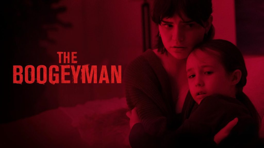 Poster for The Boogeyman showing a young woman holding and protecting a frightened girl in a dimly lit red room, with the movie title in bold red text on the left.