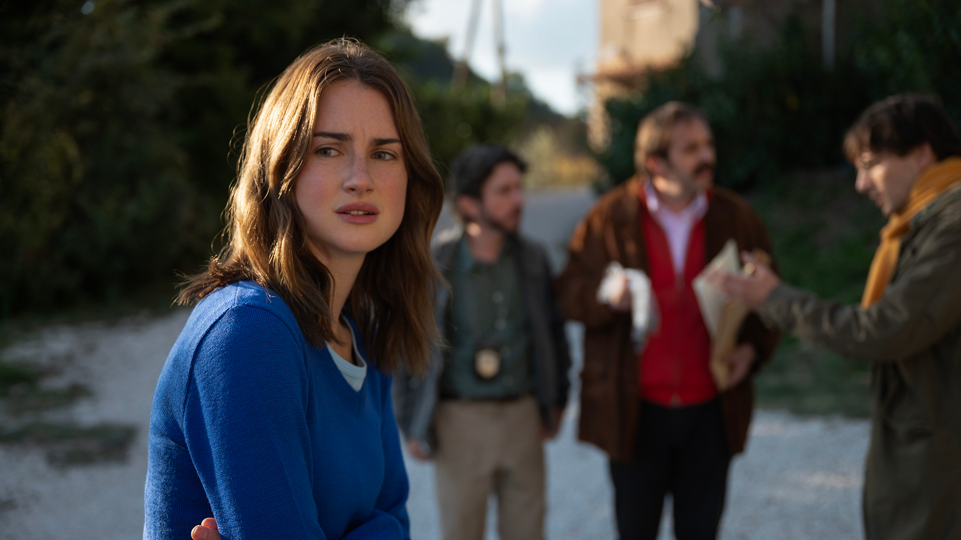 Amanda Knox with detectives in the background.