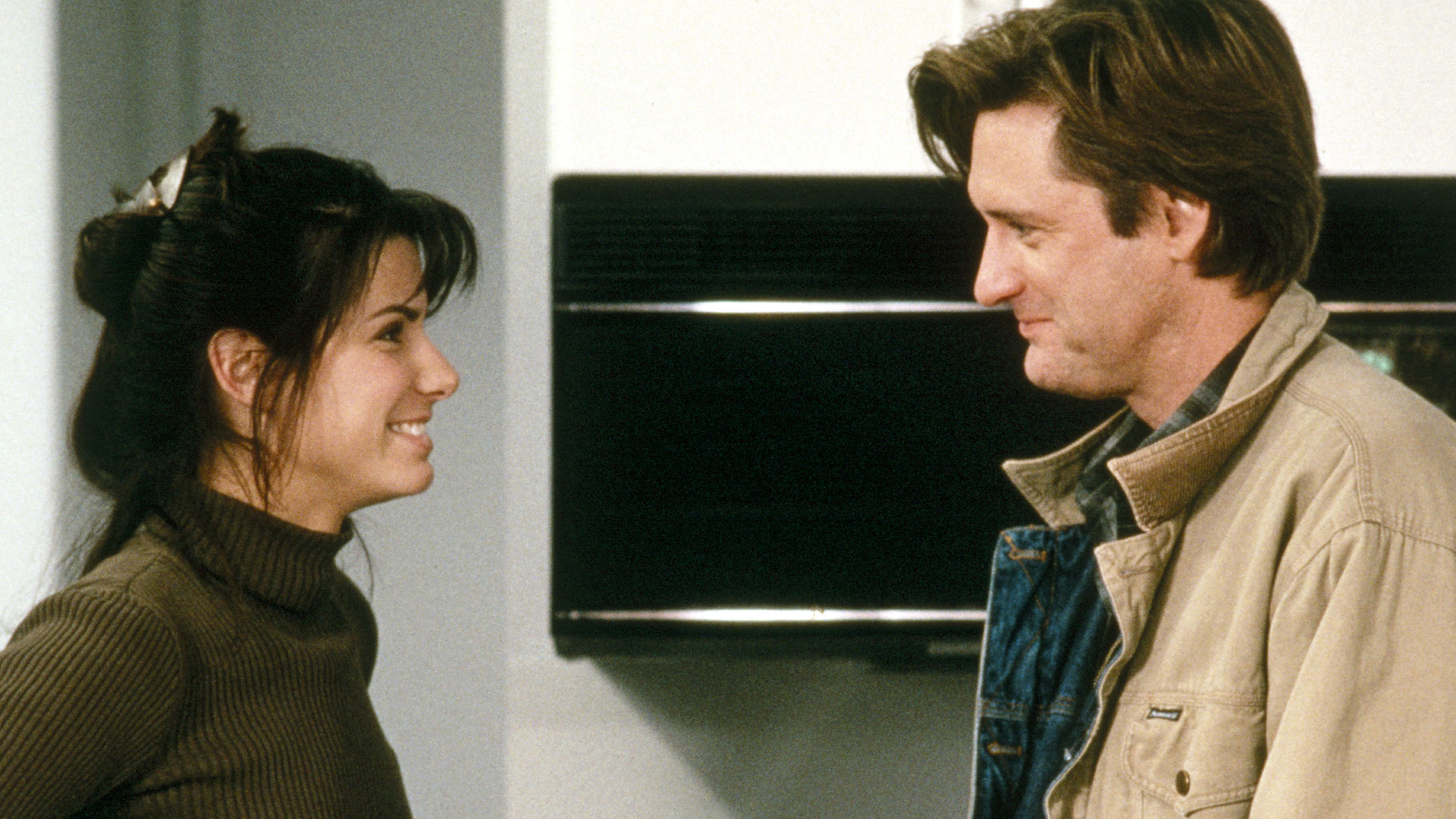 Lucy (Sandra Bullock) and Jack (Bill Pullman) smiling at each other