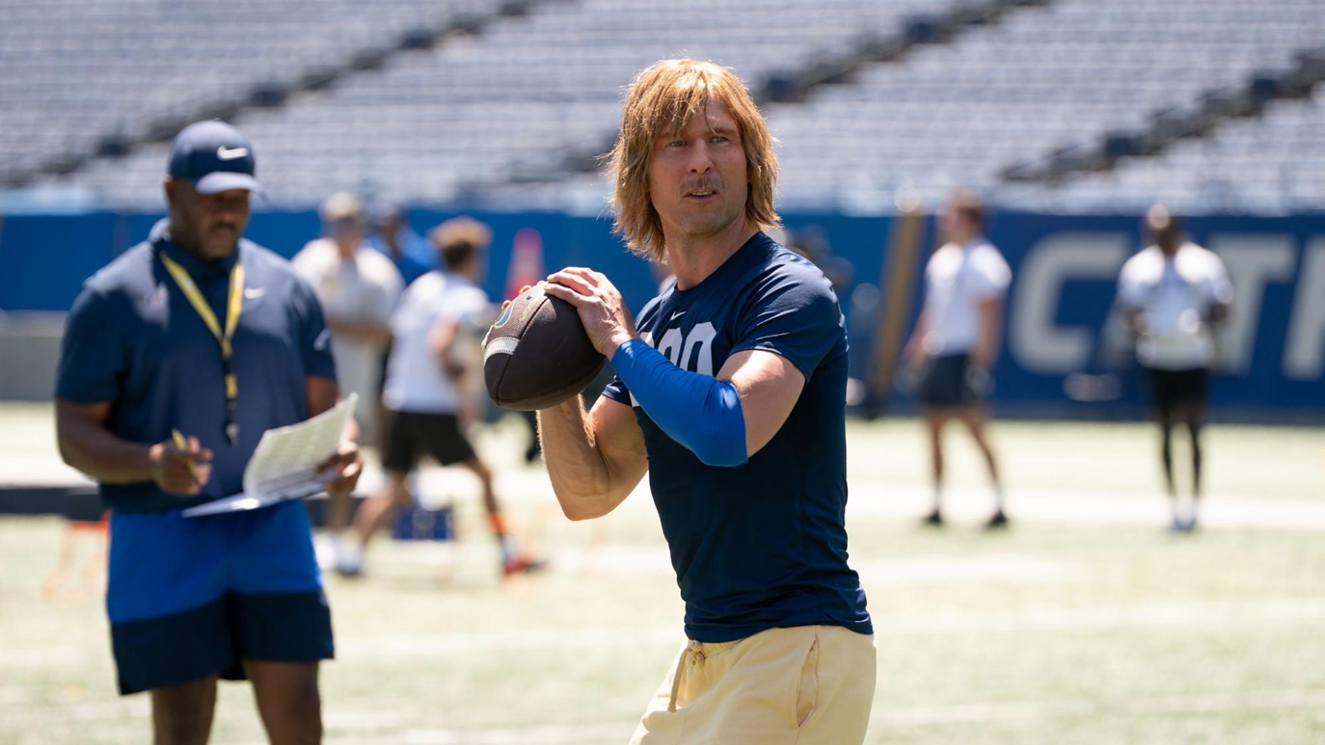 Chad Powers (Glen Powell) prepares to throw the football in training.