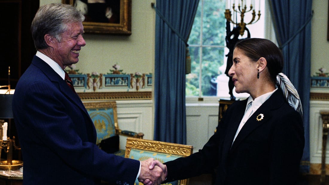 Supreme Court Justice Ruth Bader Ginsburg shaking hands.