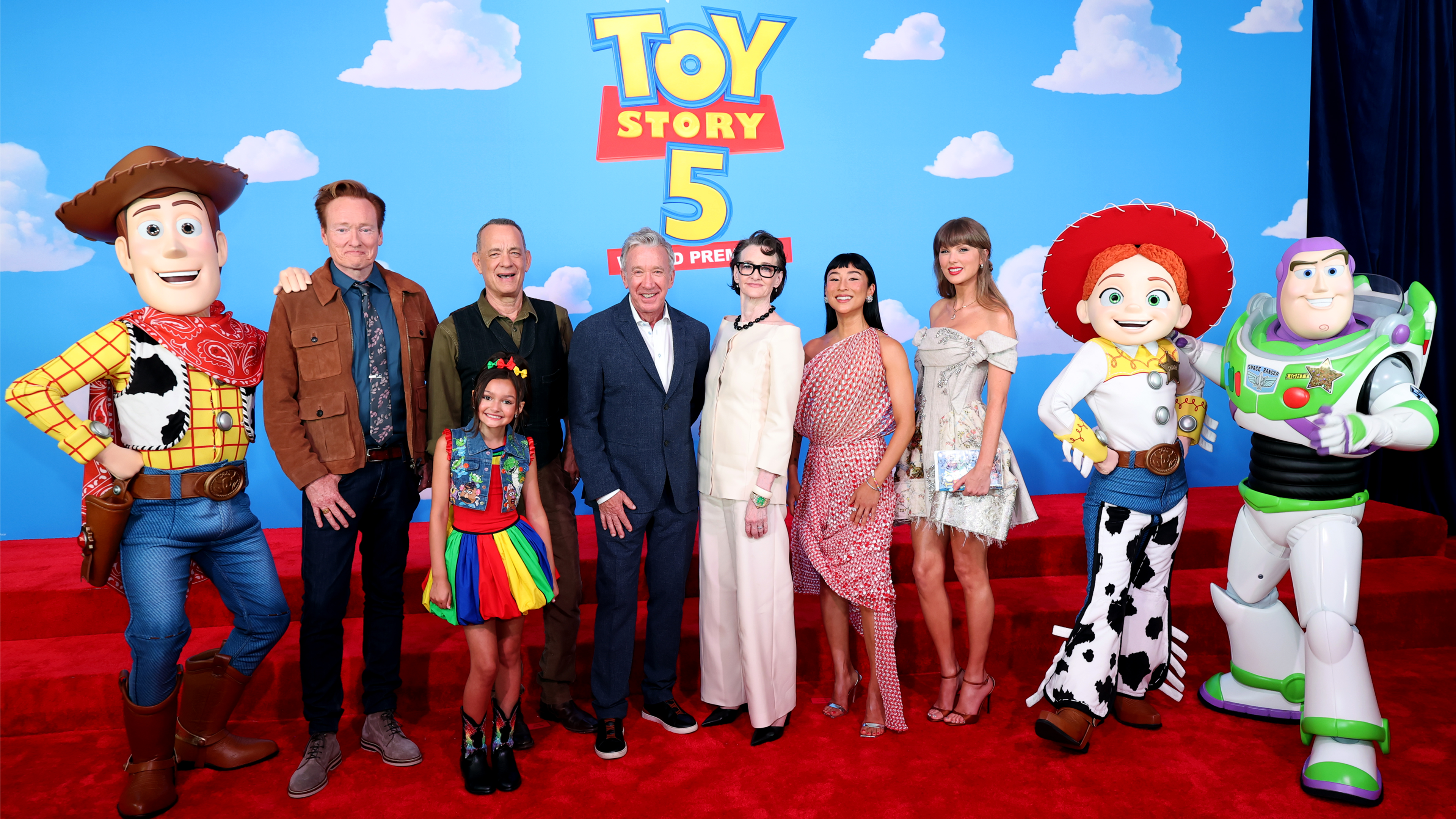 Taylor Swift with the cast of Toy Story 5 including Tom Hanks and Tim Allen alongside characters such as Woody, Buzz and Jessie at the premiere event.