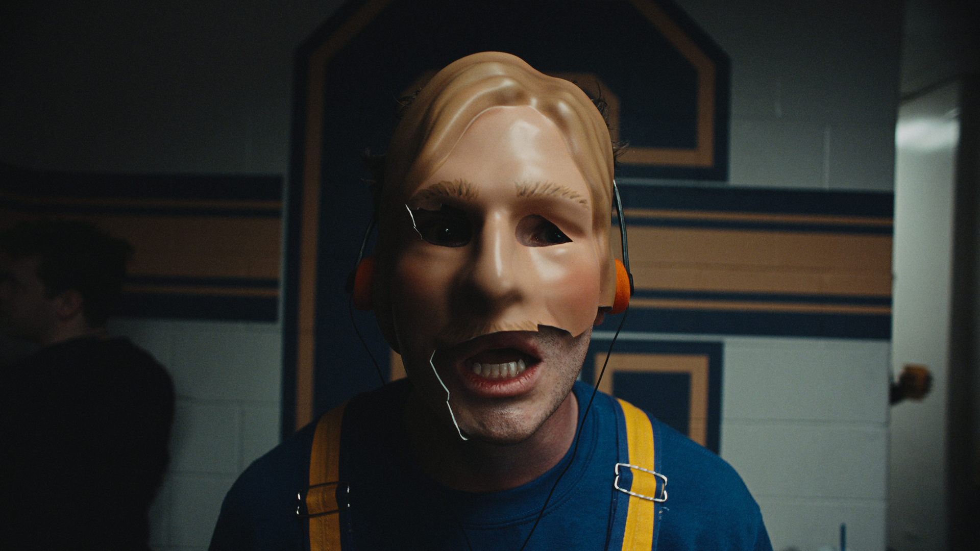 Chad Powers (Glen Powell) wearing a cracked prosthetic mask in Season 2.
