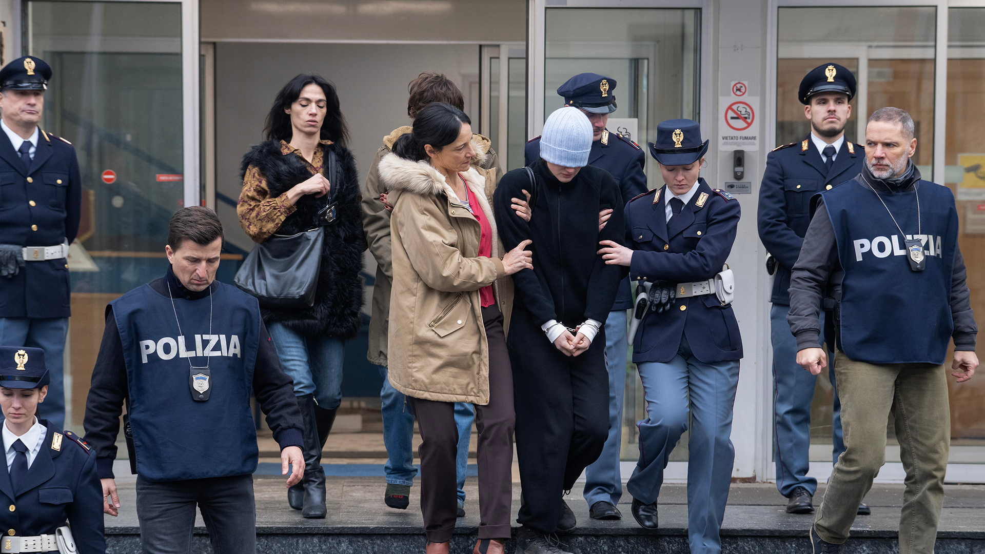 A handcuffed Amanda Knox being escorted from a building by police in Italy.