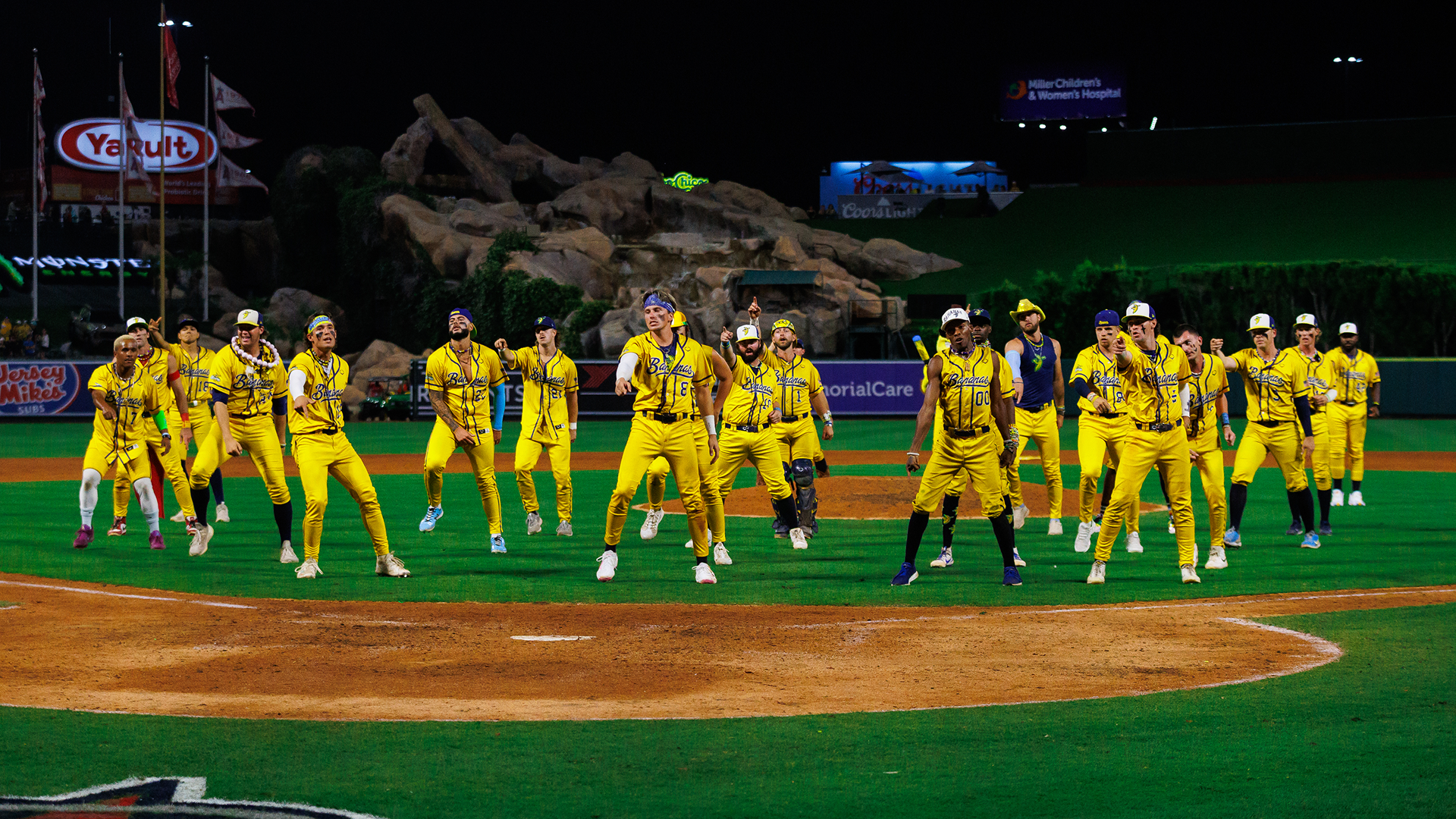 The Savannah Bananas team dancing on the baseball diamond.