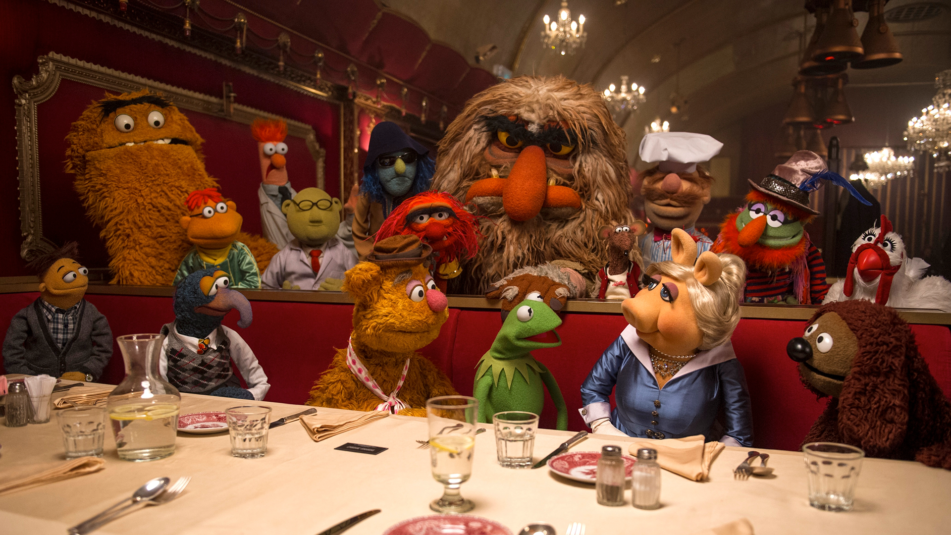 This image is from the 2014 comedy film Muppets Most Wanted and it features Muppet characters such as Kermit the Frog, Miss Piggy, Fozzie Bear, The Great Gonzo, and Walter.