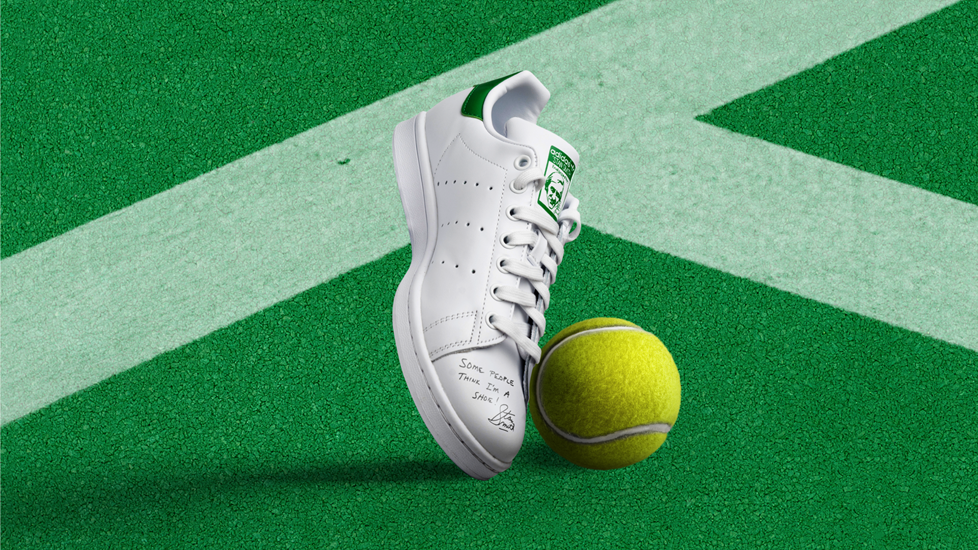 Close-up of a white Adidas sneaker next to a tennis ball.