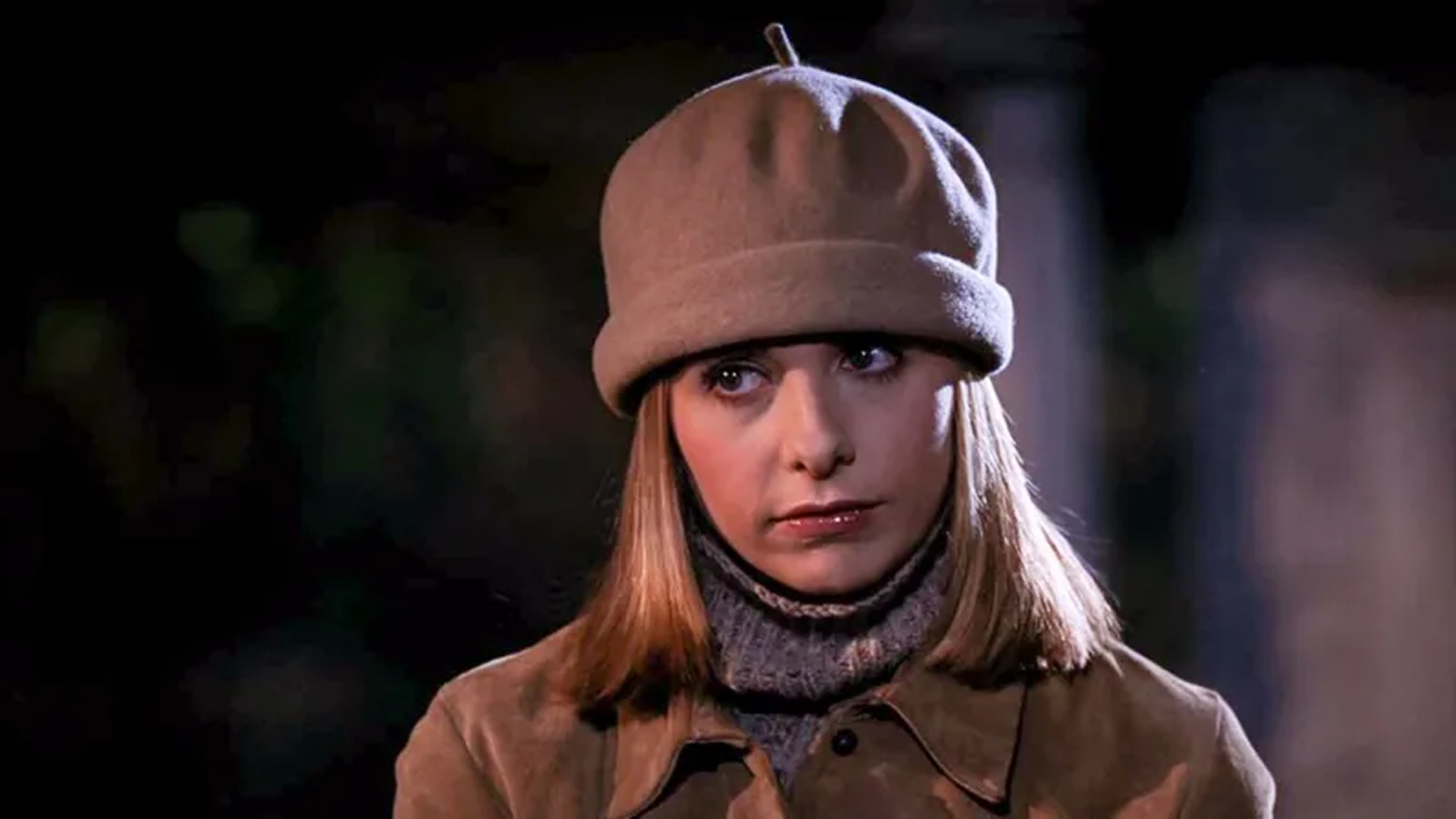 Buffy (Sarah Michelle Gellar), dressed in winter clothes and a hat, looks out of frame disapprovingly.