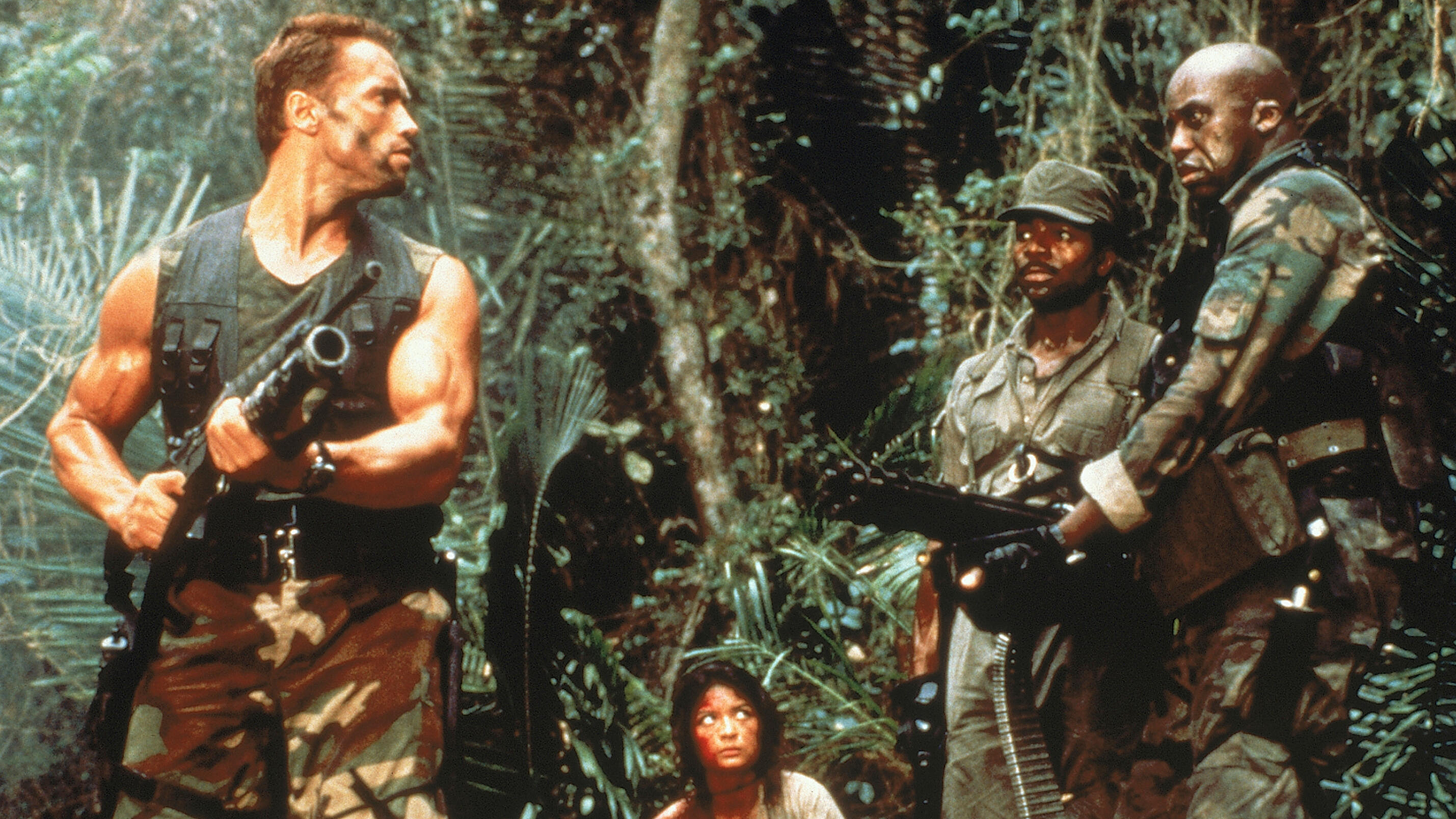 Dutch, Anna, Dillon and Mac traverse the jungle with their weapons in Predator.
