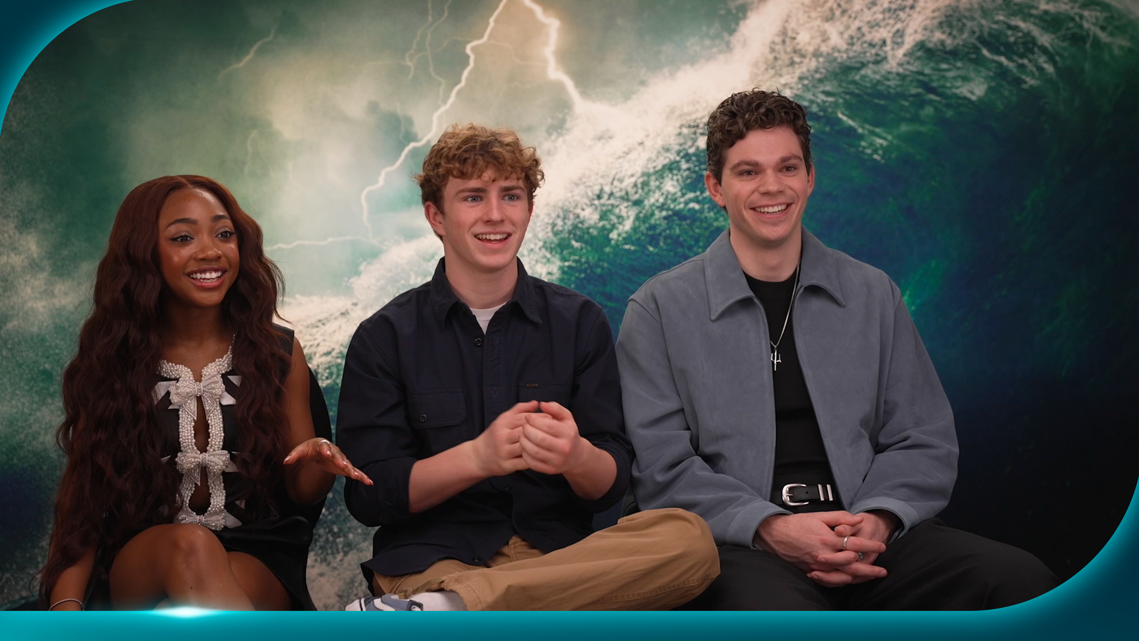 Percy Jackson and The Olympians cast members Leah Jeffries, Walker Scobell, and Daniel Diemer sat for an interview, with an ocean waves background