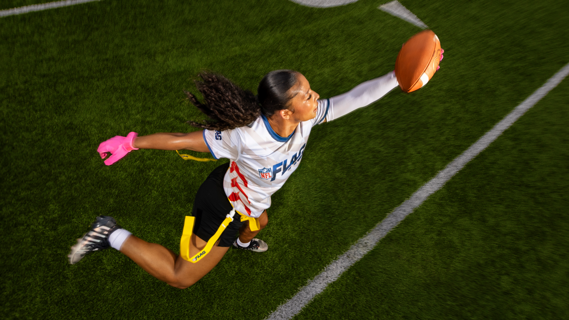 A young woman reaches out to grab the football.