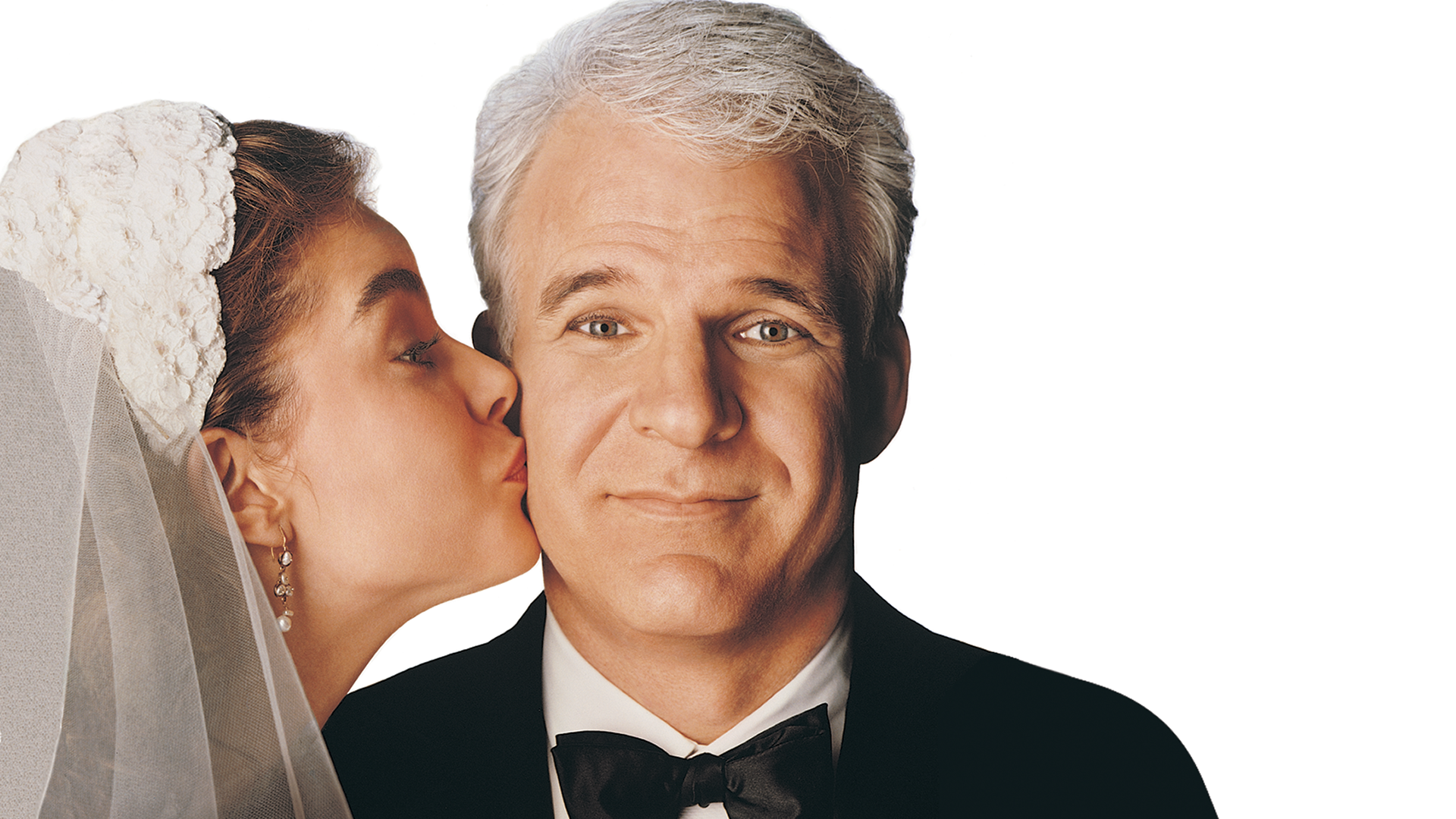 A classic promotional image from Father of the Bride shows George Banks (Steve Martin) wearing a black tuxedo and bow tie with a slightly overwhelmed smile, as his daughter Annie Banks (Kimberly Williams-Paisley) kisses his cheek while wearing a white wedding veil.