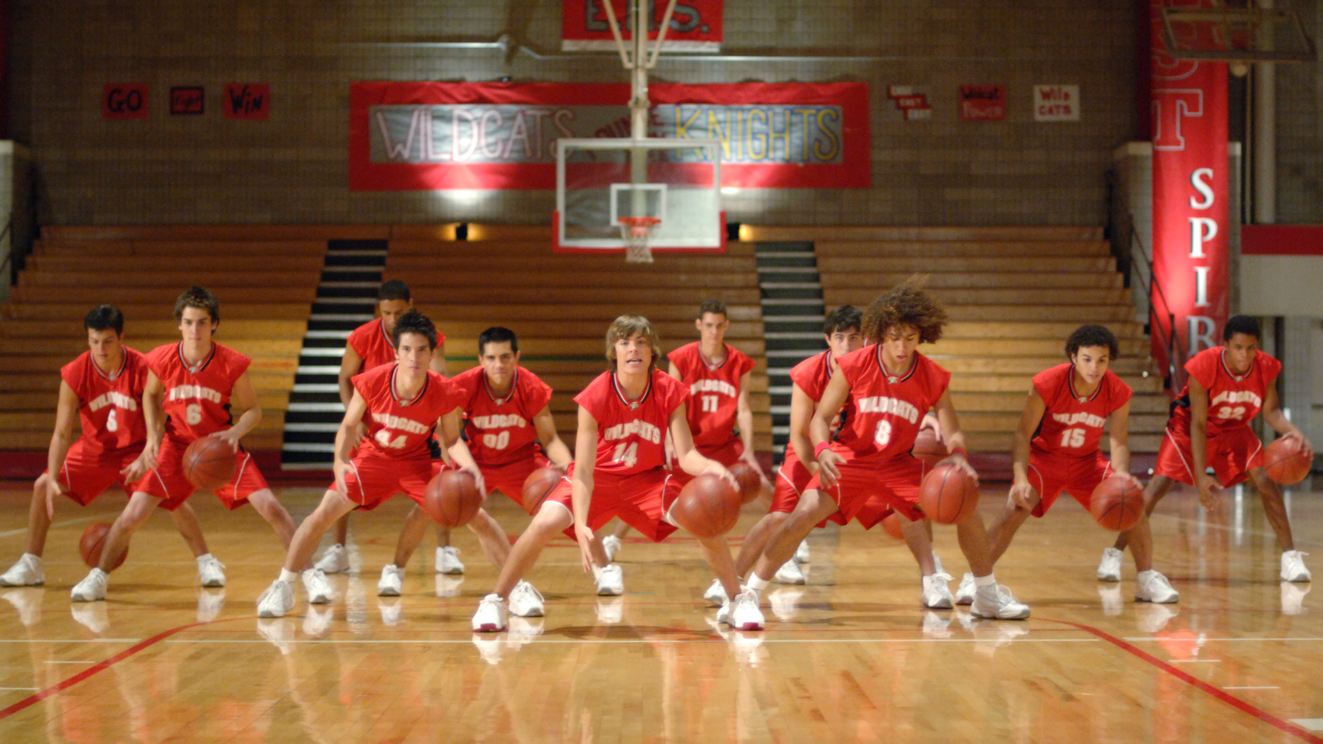 A group of Wildcats basketball players doing choreography with basketballs 