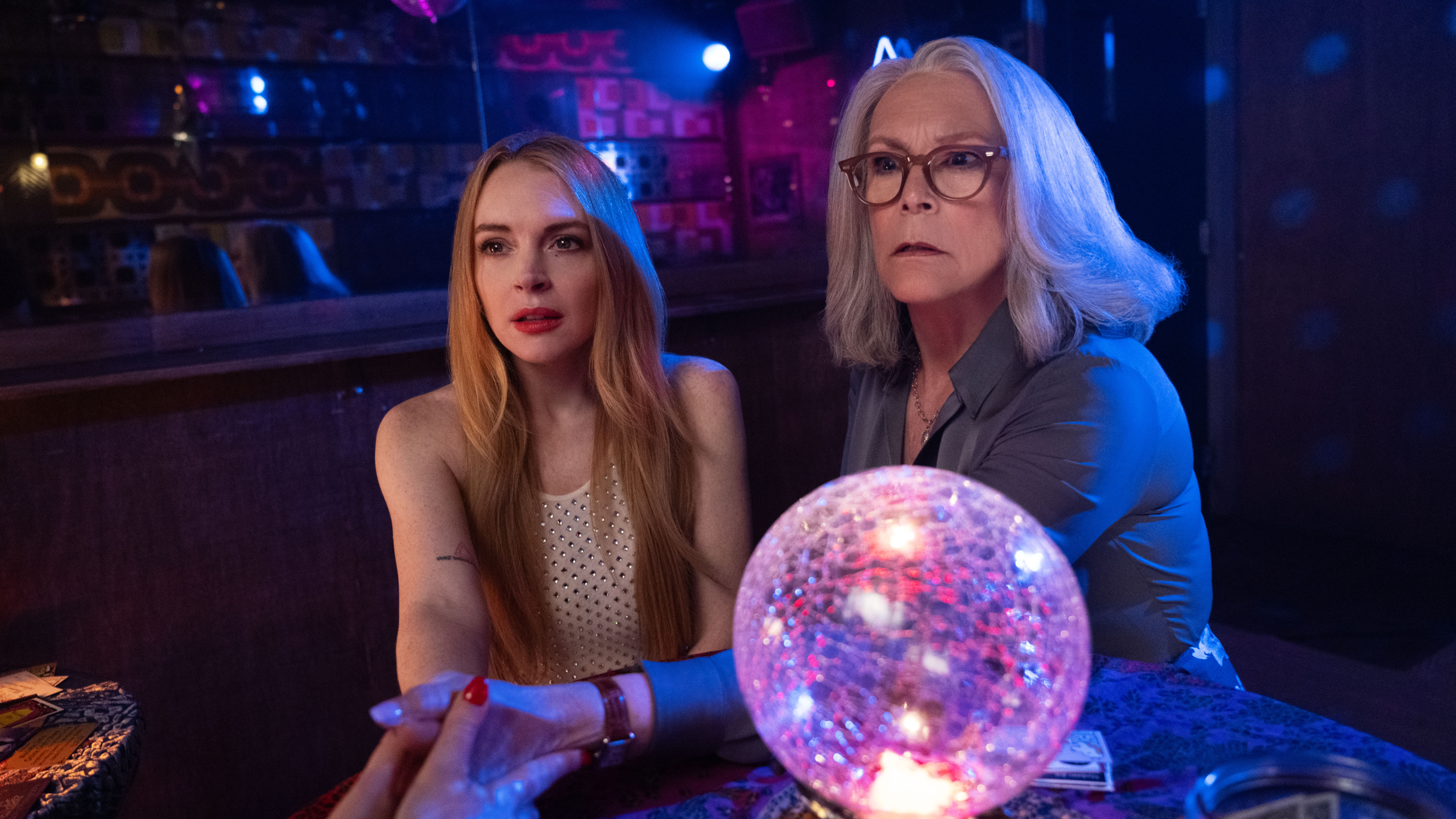 Anna (Lindsay Lohan) and Tess Coleman (Jamie Lee Curtis) sit at a table in a bar.