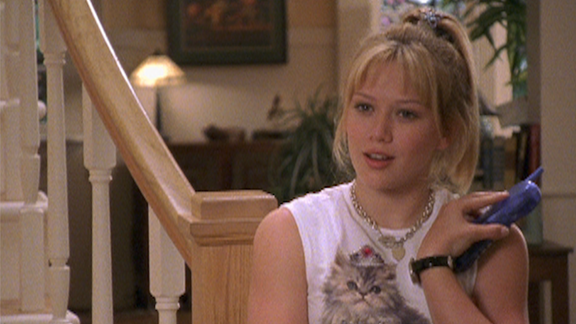 Lizzie McGuire (Hilary Duff) holds a purple cell phone in her home in a still from Lizzie McGuire