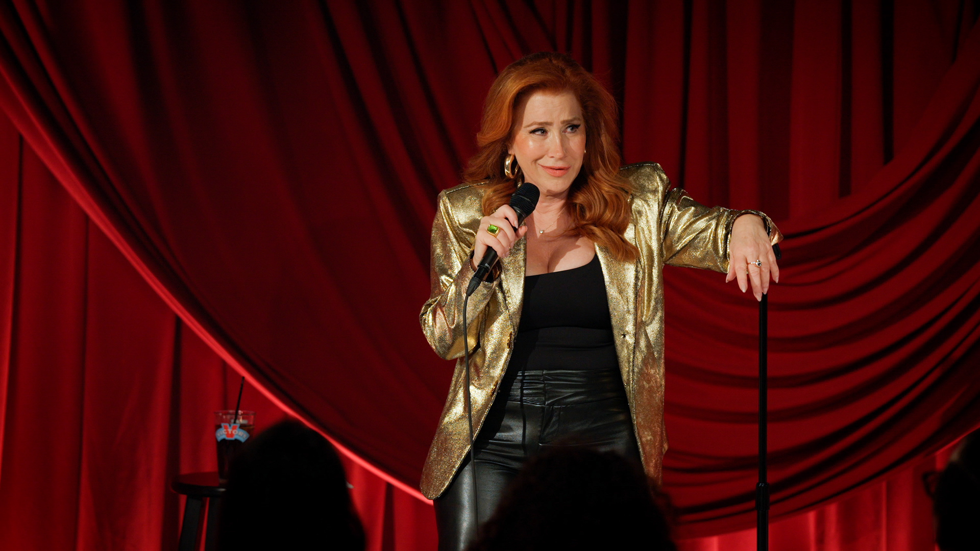 This image features actress and comedian Lisa Ann Walter on stage during a performance. Walter is set to release her debut stand-up comedy special, titled Lisa Ann Walter: It Was an Accident, on Hulu.