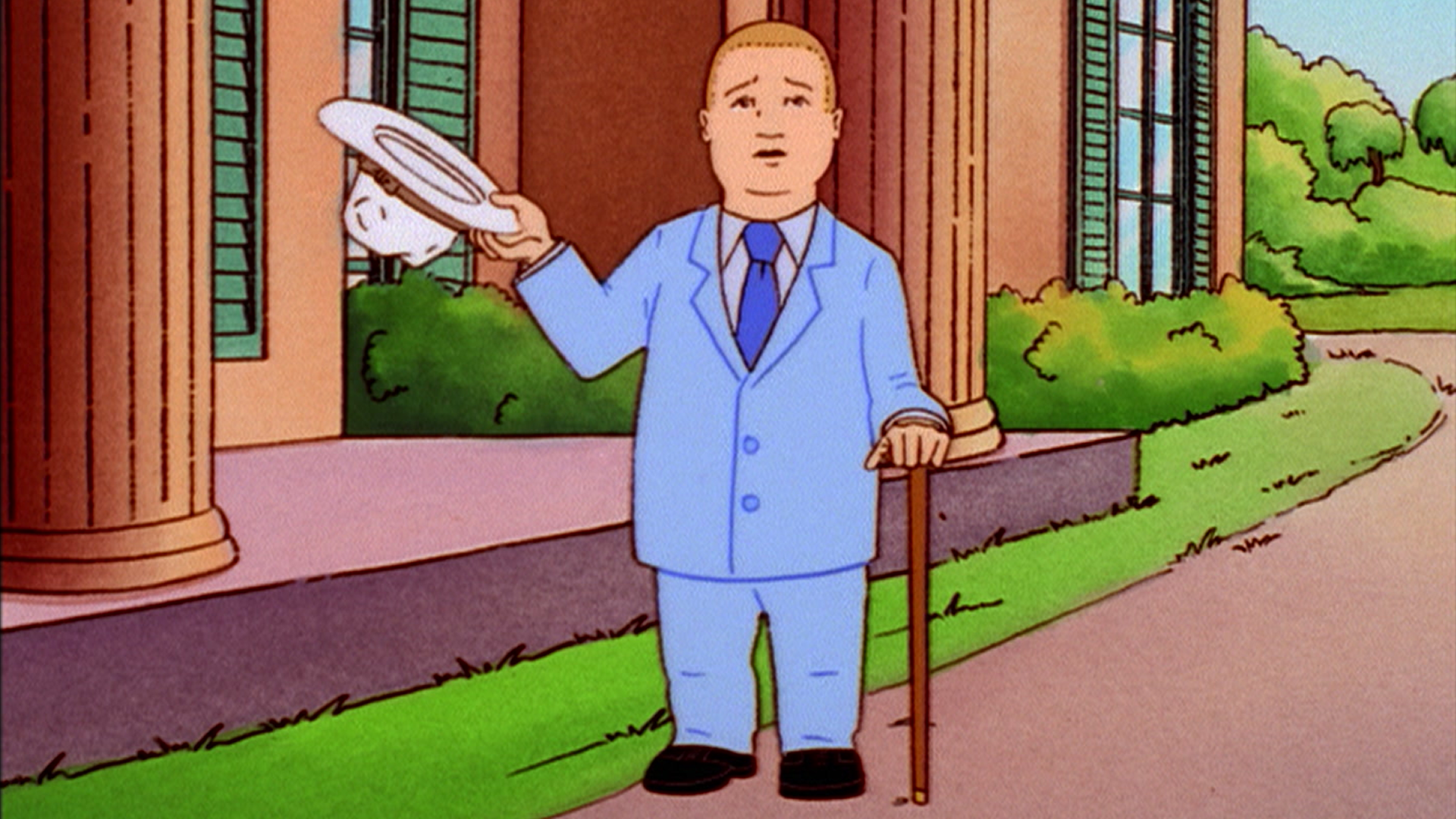 Bobby (Pamela Adlon), dressed in a pale-blue suit, lifts his white hat while holding a cane outside a mansion.