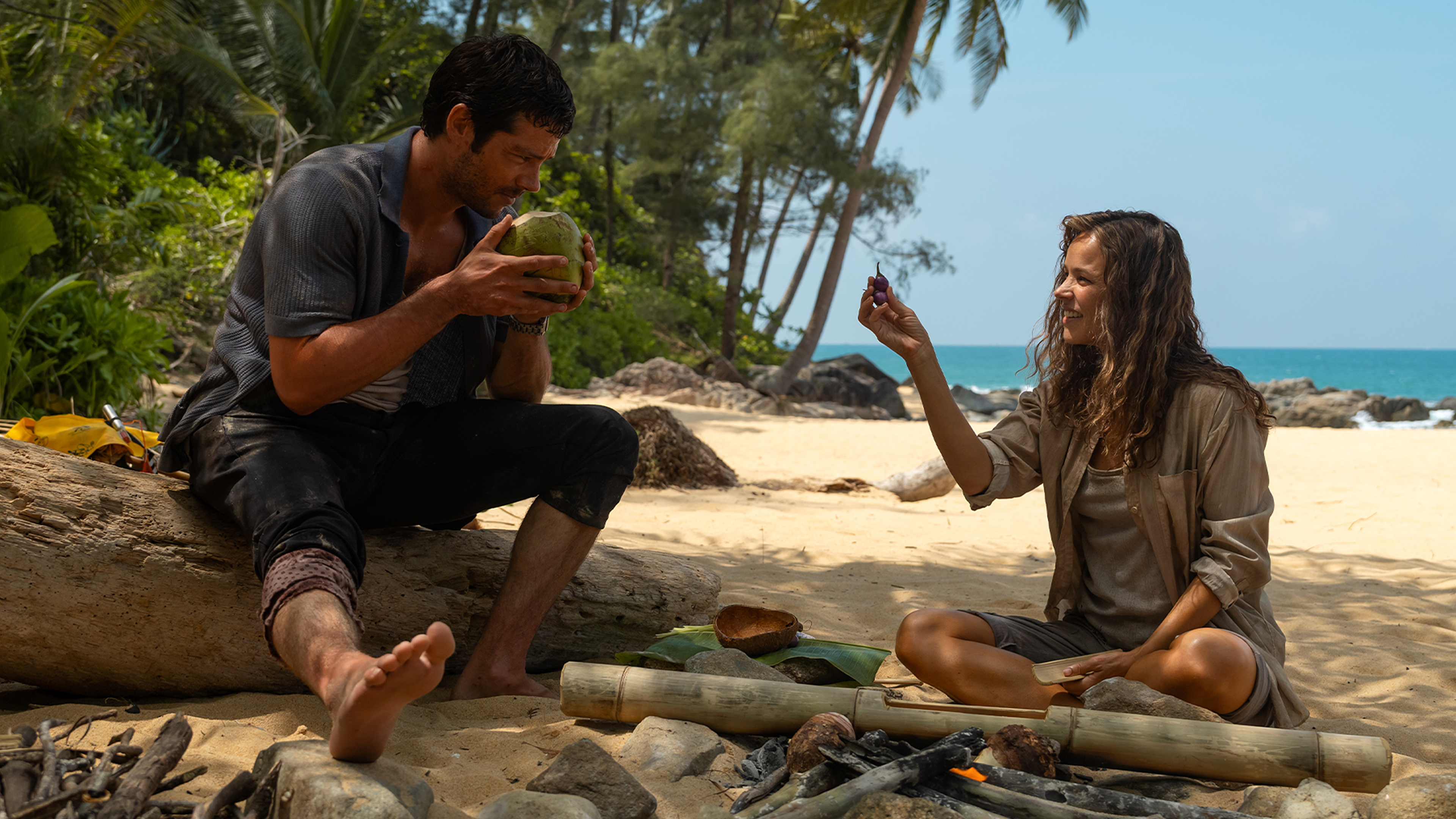 Linda Liddle (Rachel McAdams) on the beach with her boss Bradley (Dylan O'Brien) after the plane crash.