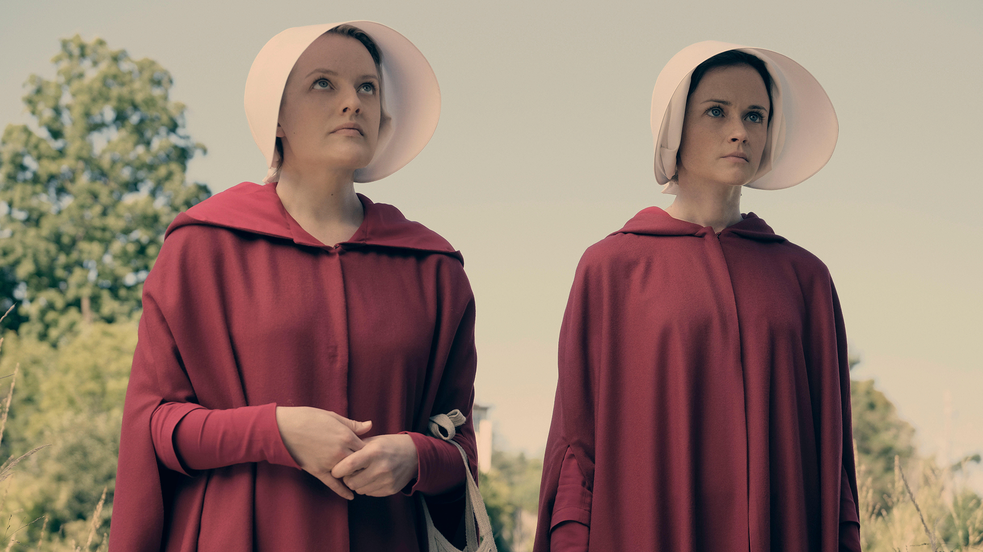 June Osborne (Elisabeth Moss) e a Dra. Emily Malek (Alexis Bledel) com seus trajes de Aia.