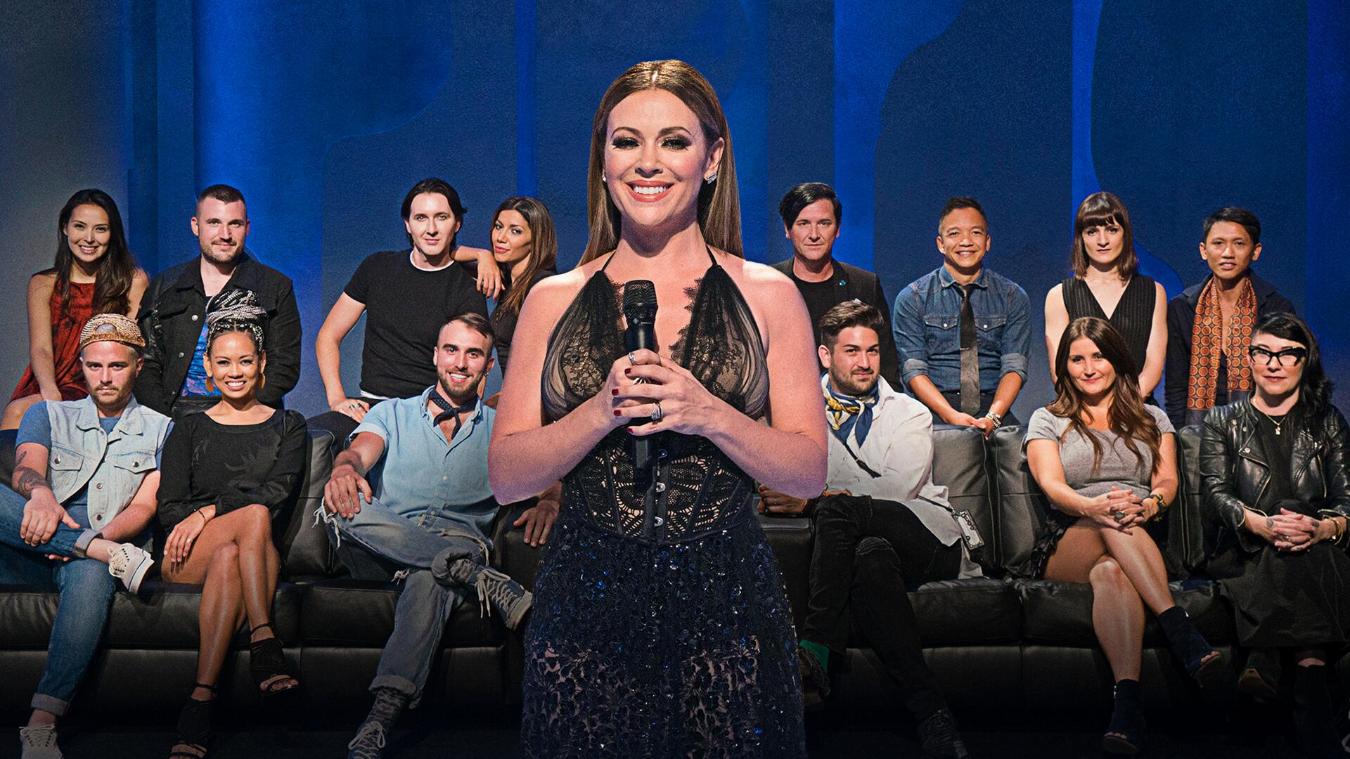 This image features actress and host Alyssa Milano on the set of the reality television series Project Runway All Stars, surrounded by contestants from the competition. 