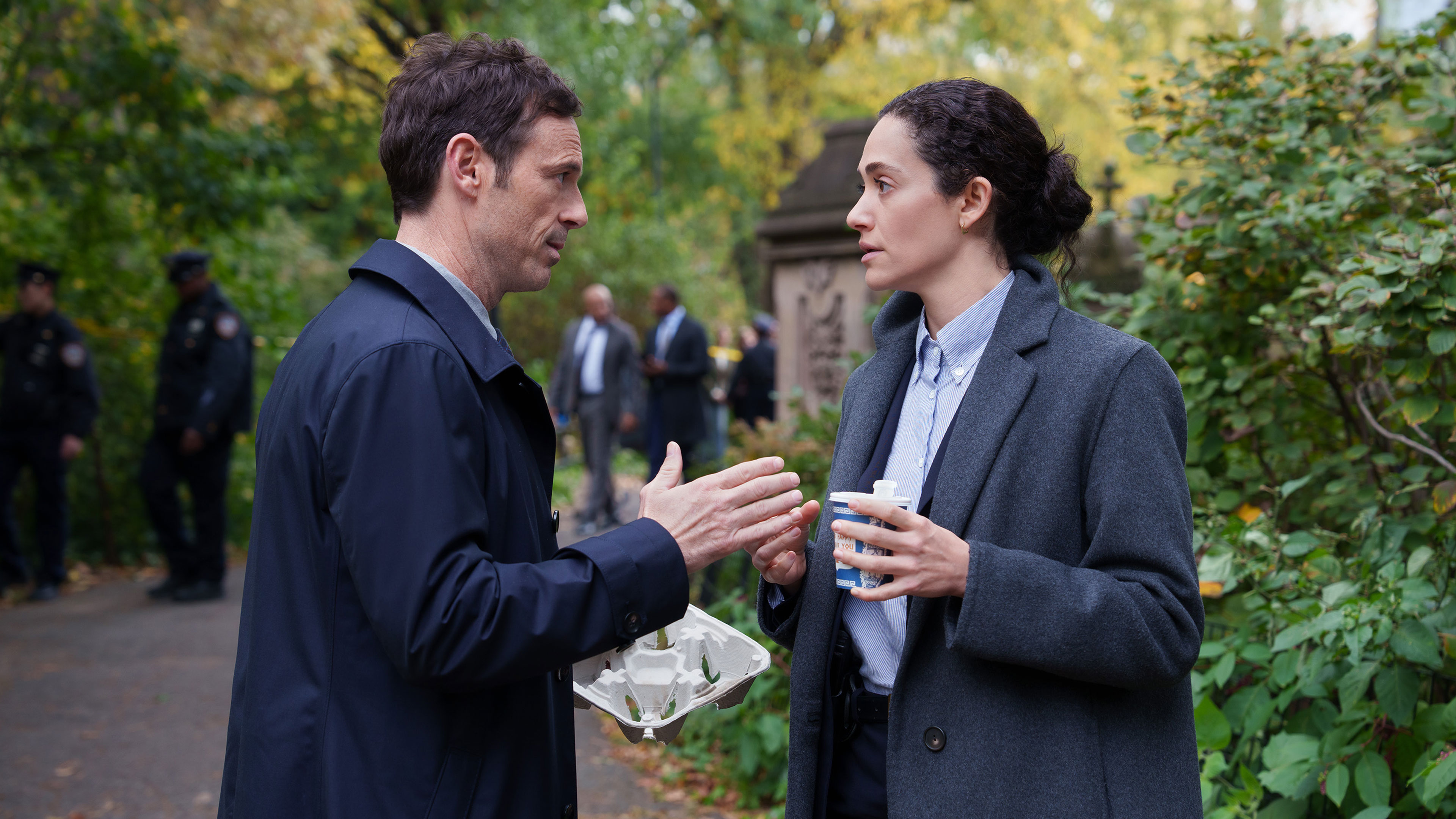 Danny and Alice talk near an outdoor investigation scene.