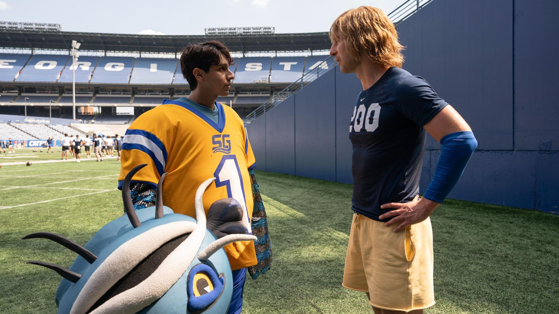Chad Powers (Glen Powell) talks with Danny (Frankie Rodriguez) inside the stadium in the first season of Chad Powers.