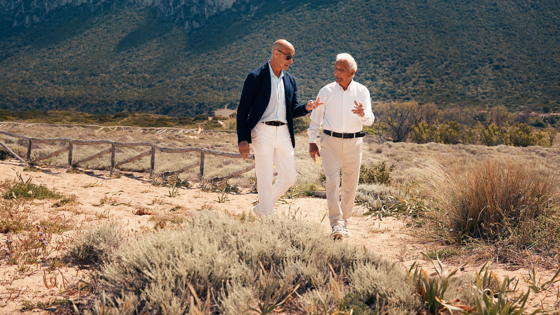 Stanley Tucci walks through the hilly Italian countryside with a local guide