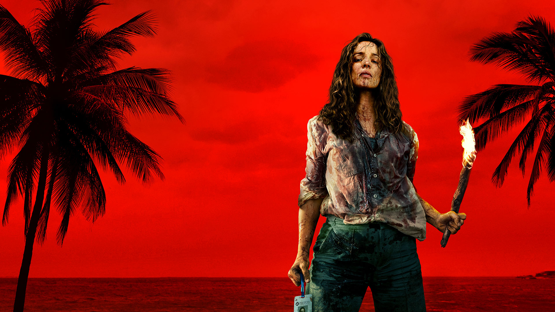 Key art for Send Help featuring a bloodied survivor holding a flaming torch on a tropical beach against a vivid red sky.