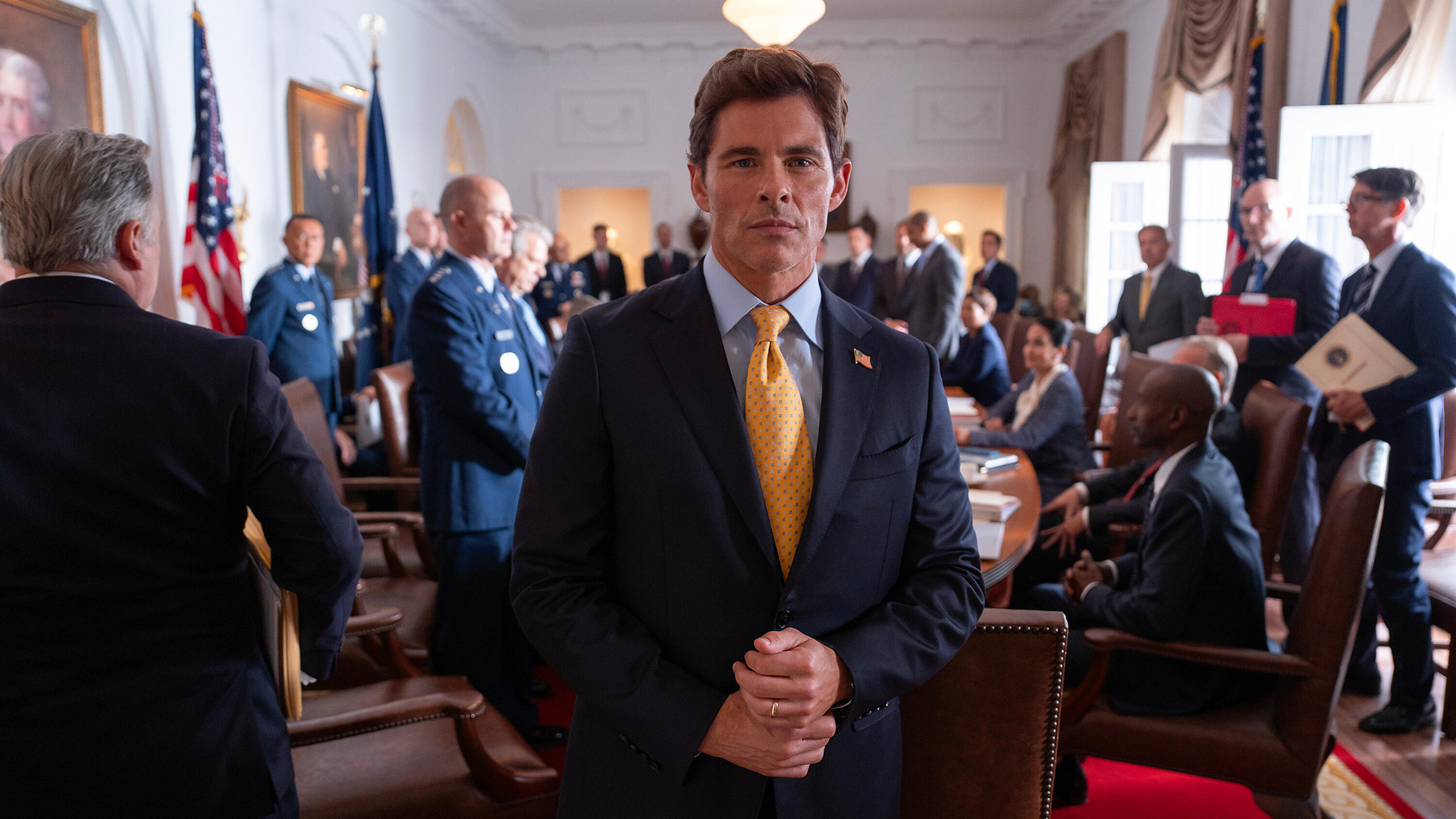 O presidente Cal Bradford (James Marsden) encara a câmera em uma sala movimentada da Casa Branca em cena de Paradise