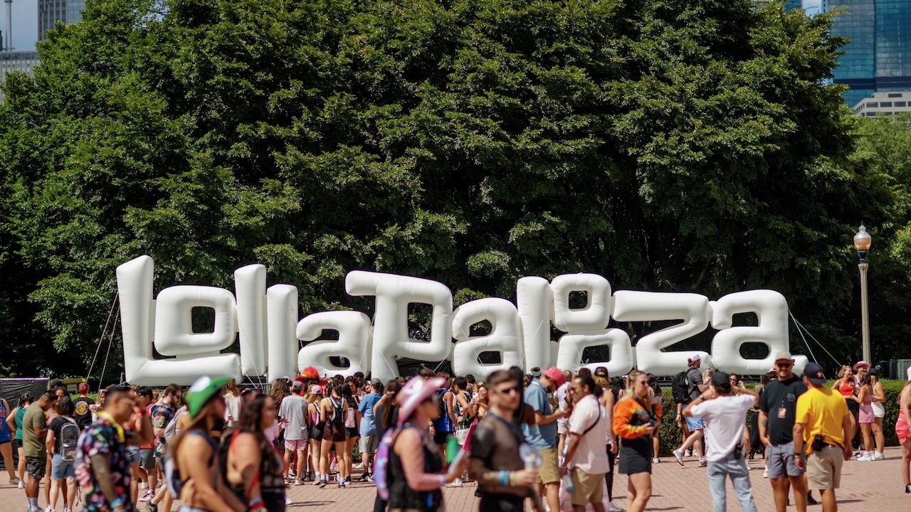Fans walk through Grant Park past the large Lollapalooza sign during the annual Chicago music festival.