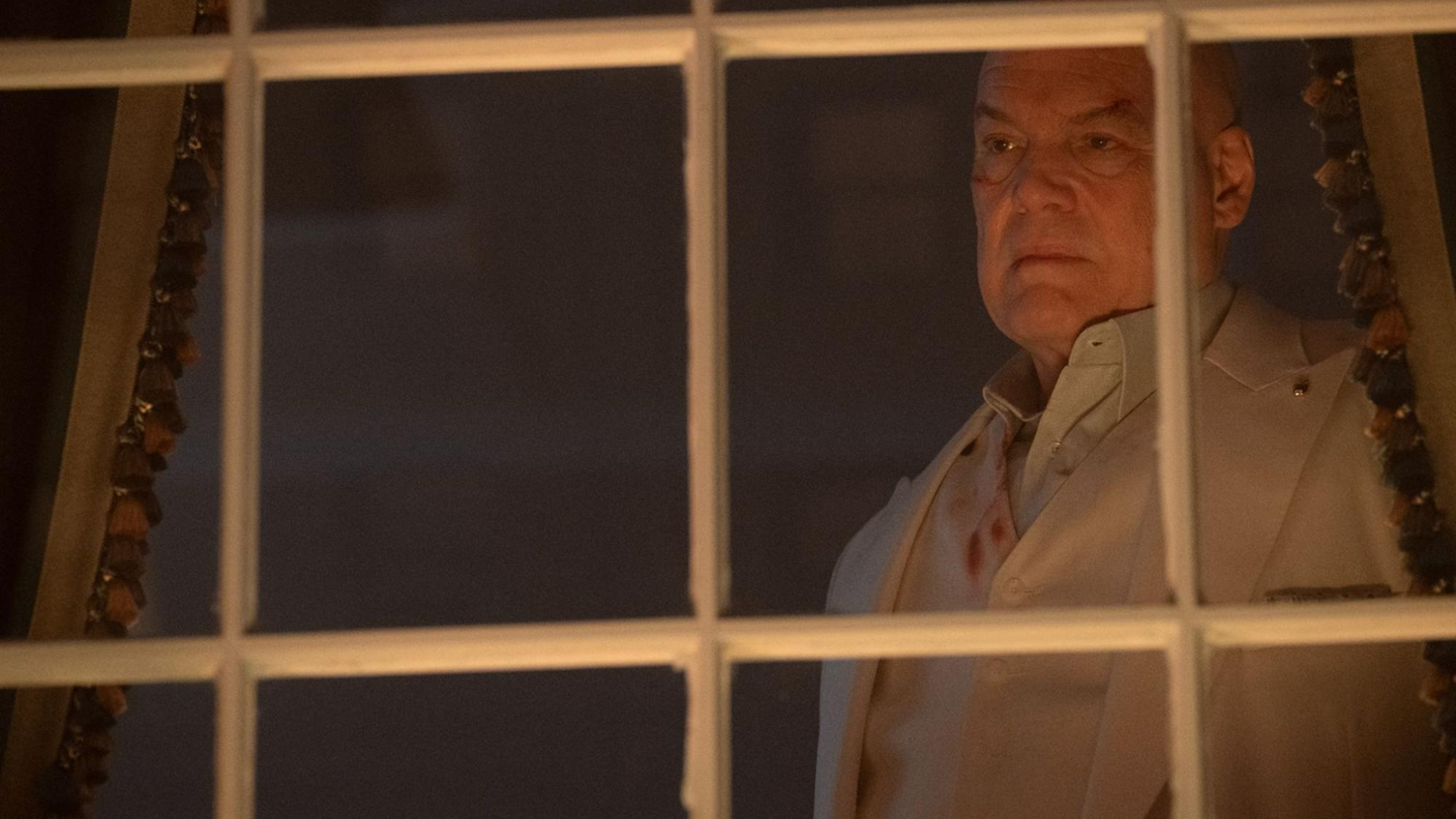 Wilson Fisk (Vincent D'Onofrio) looks out of the window as the people of New York protest his Safer Streets act.
