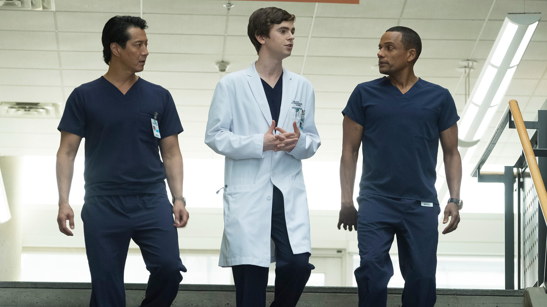 Shaun Murphy (Freddie Highmore) walking with two male colleagues in The Good Doctor.