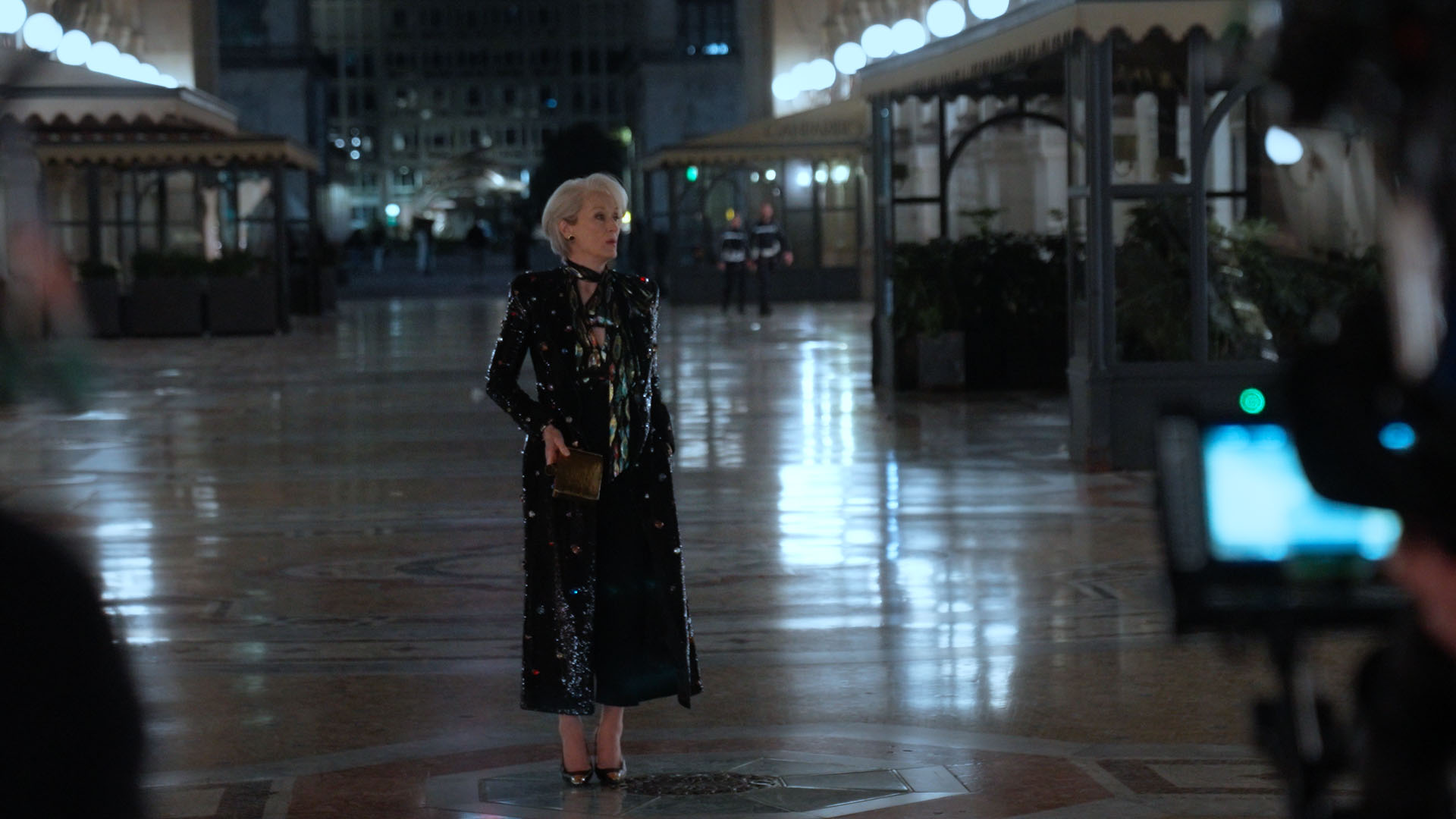 Miranda Priestly (Meryl Streep) standing outside at night in a black gown.