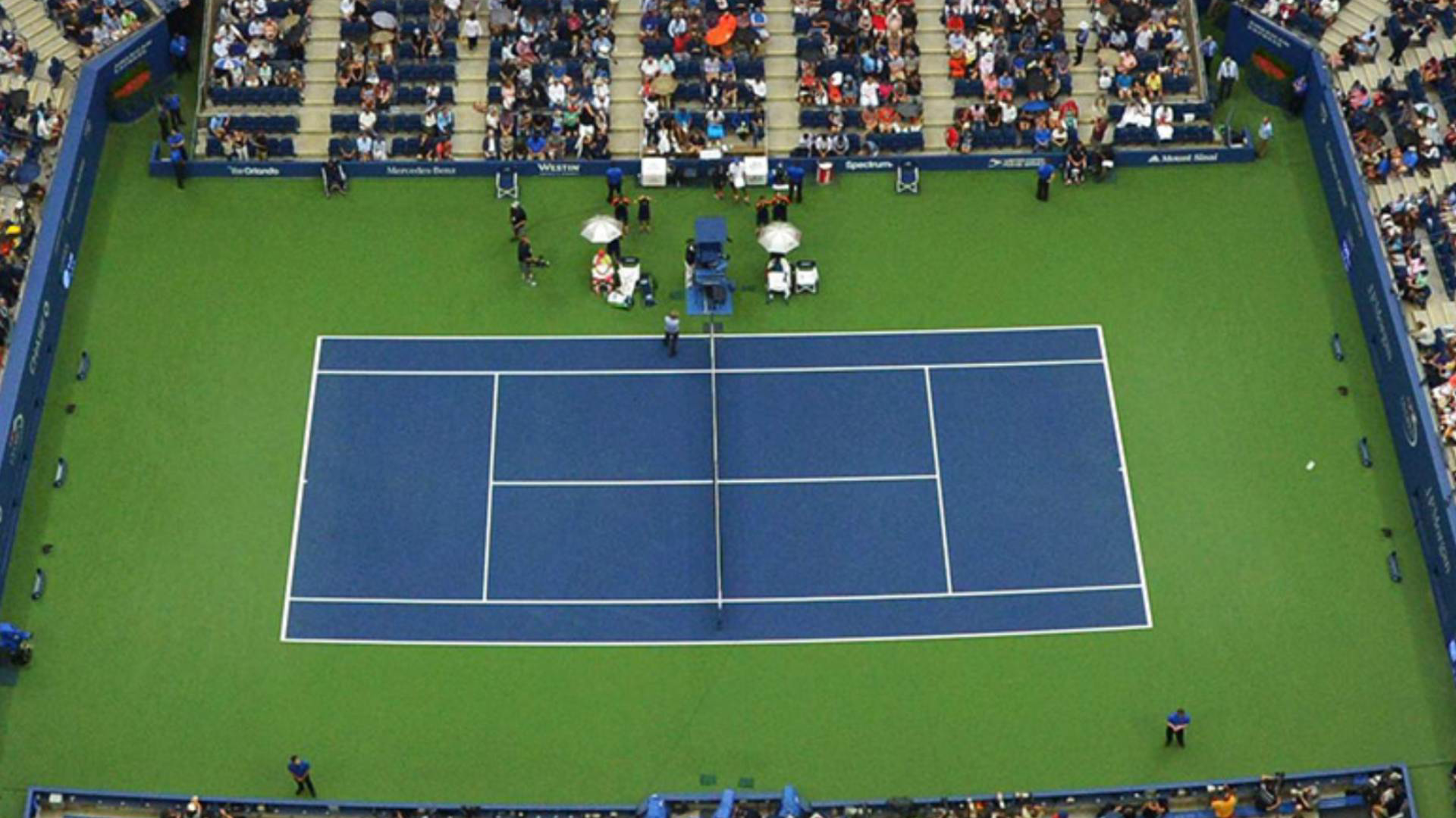This image shows a high-angle view of the tennis court at the Arthur Ashe Stadium, which is the main venue for the U.S. Open.