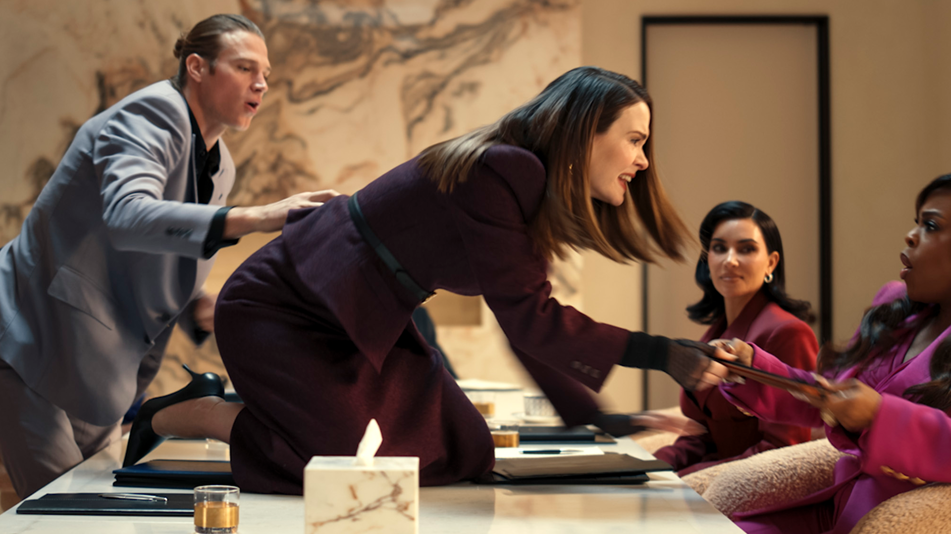 会議中に別の女性に立ち向かっている "カー"・レーン（サラ・ポールソン）。