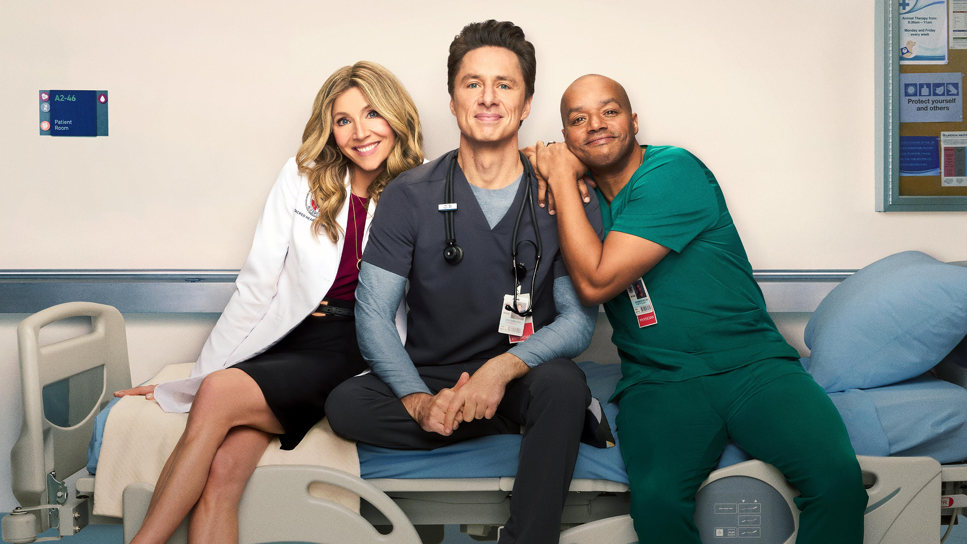 Elliot (Sarah Chalke), J.D. (Zach Braff), and Turk (Donald Faison) sit on a gurney, smiling
