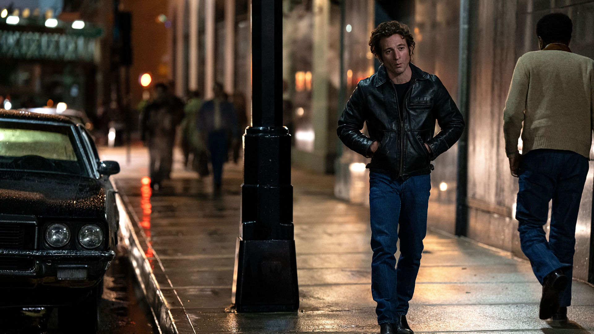 Bruce Springsteen (Jeremy Allen White) walks along a sidewalk at night.