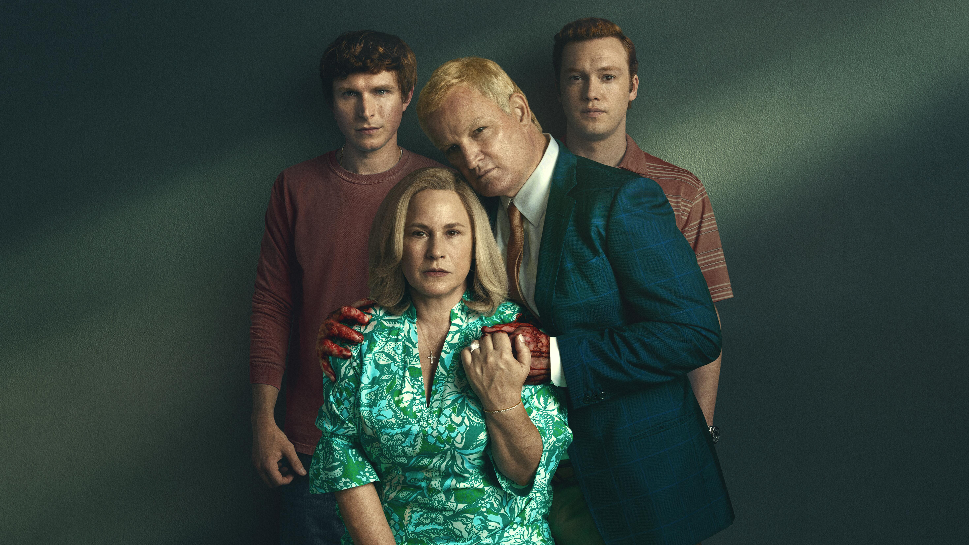 Maggie Murdaugh (Patricia Arquette) sits with Alex Murdaugh (Jason Clarke) embracing her with bloody hands. Their sons Paul (Johnny Berchtold) and Buster (Will Harrison) stand behind them